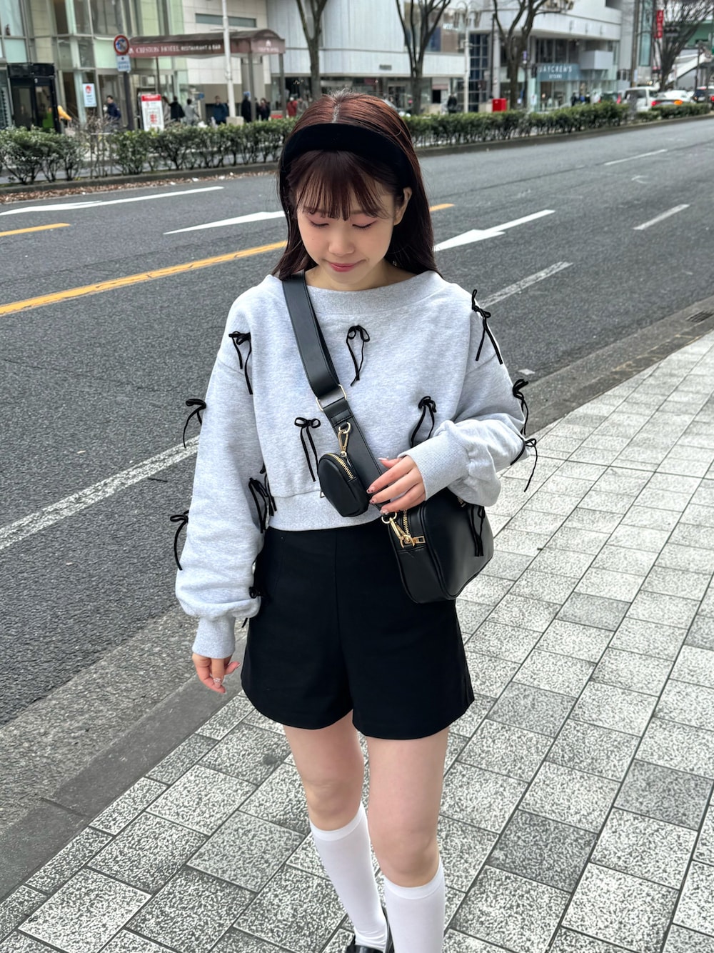 グレー系のスウェット、ブラック系のボディバッグ/ウエストポーチ、ブラック系のパンツを着用したレディースの春コーディネートの1枚目の写真
