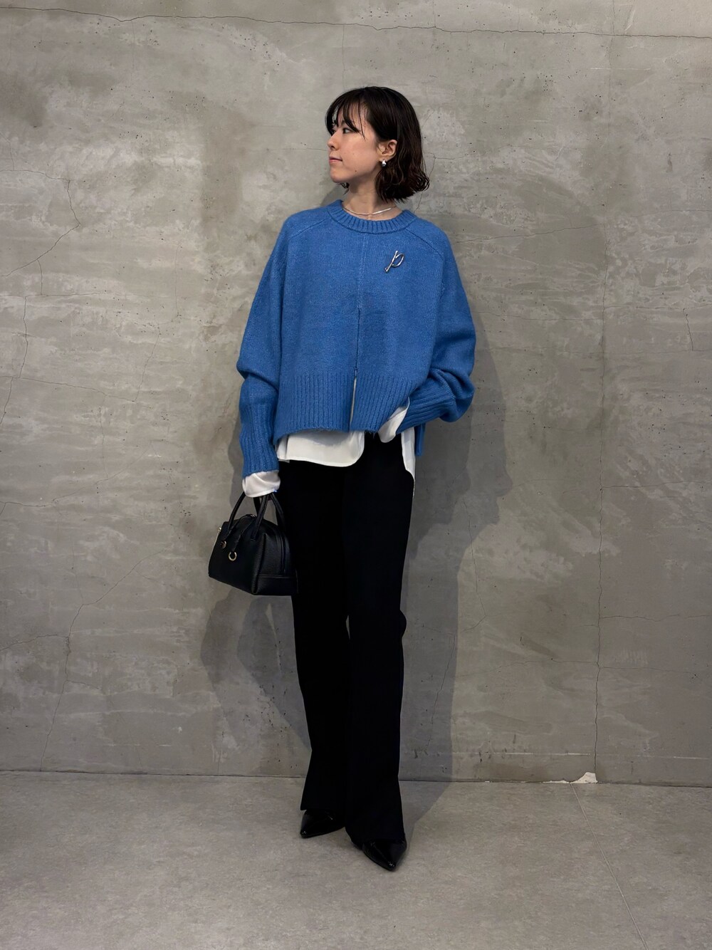 ブルー系のニット/セーター、ホワイト系のシャツ/ブラウス、ブラック系のその他パンツを着用したレディースの秋コーディネートの1枚目の写真