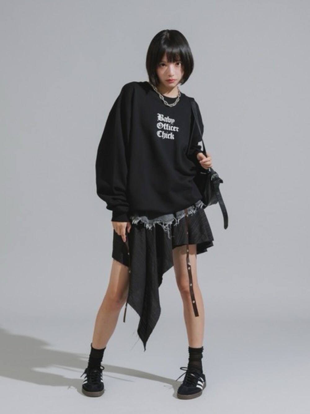 ブラック系のスウェット、ブラック系のデニムスカート、ブラック系のスニーカーを着用したレディースの秋コーディネートの1枚目の写真