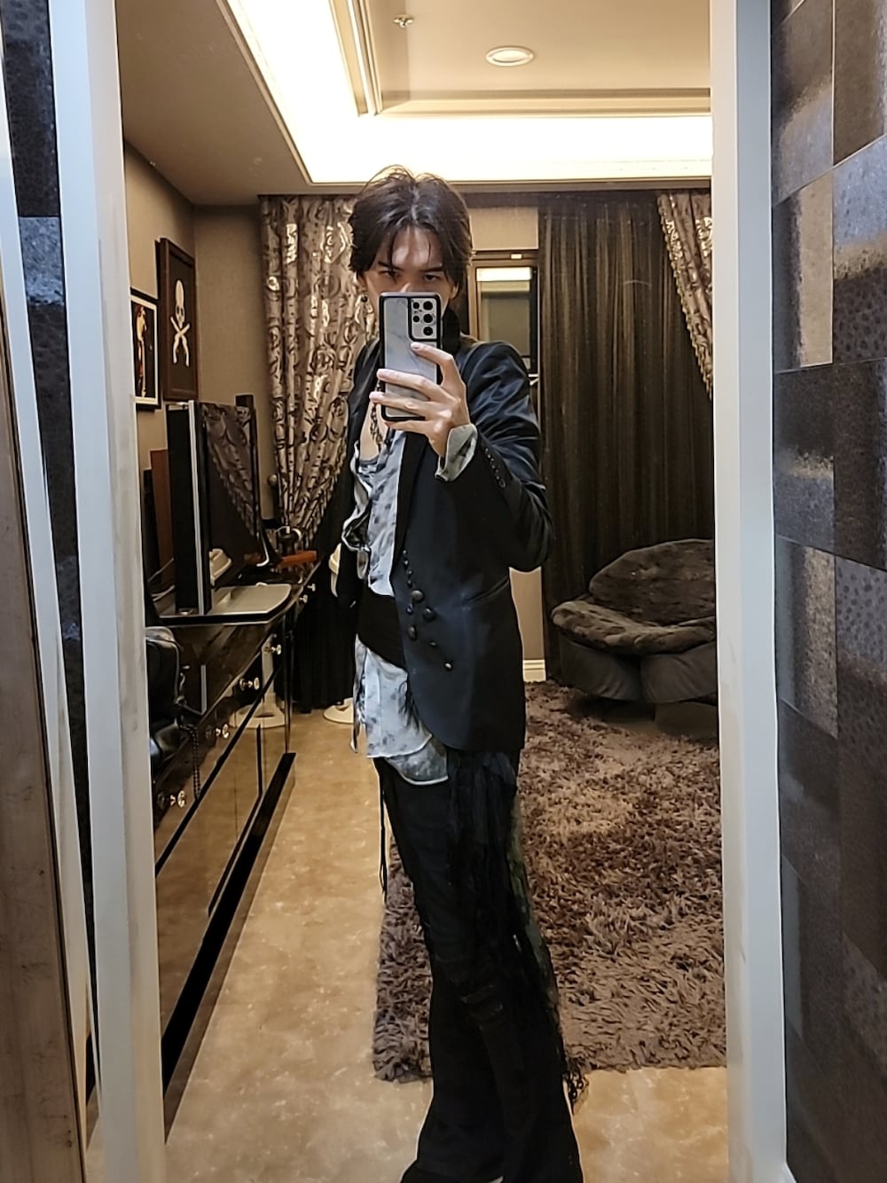 ブラック系のチェスターコートを着用したメンズの春コーディネートの1枚目の写真