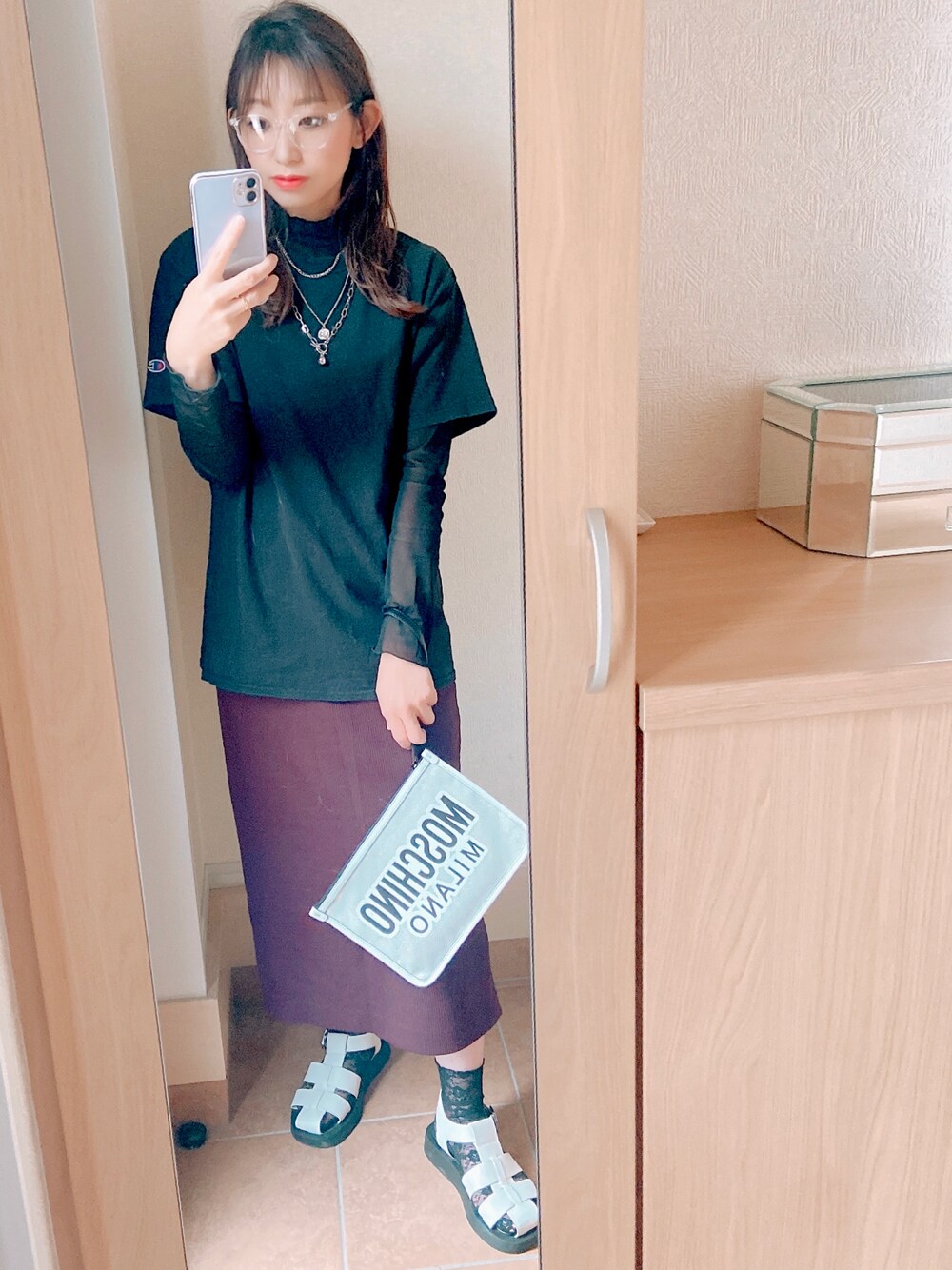 ブラック系のTシャツ/カットソー、ホワイト系のクラッチバッグ、ホワイト系のサンダルを着用したレディースの夏コーディネートの1枚目の写真