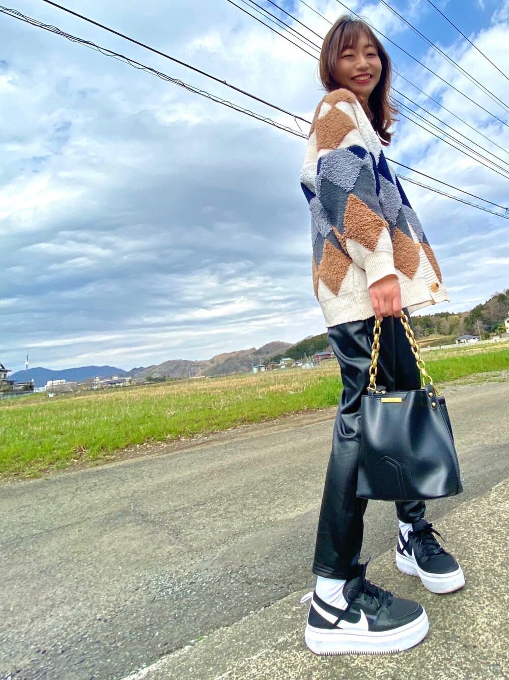 その他のカーディガン/ボレロ、ブラック系のショルダーバッグ、ブラック系のスニーカーを着用したレディースの春コーディネートの1枚目の写真