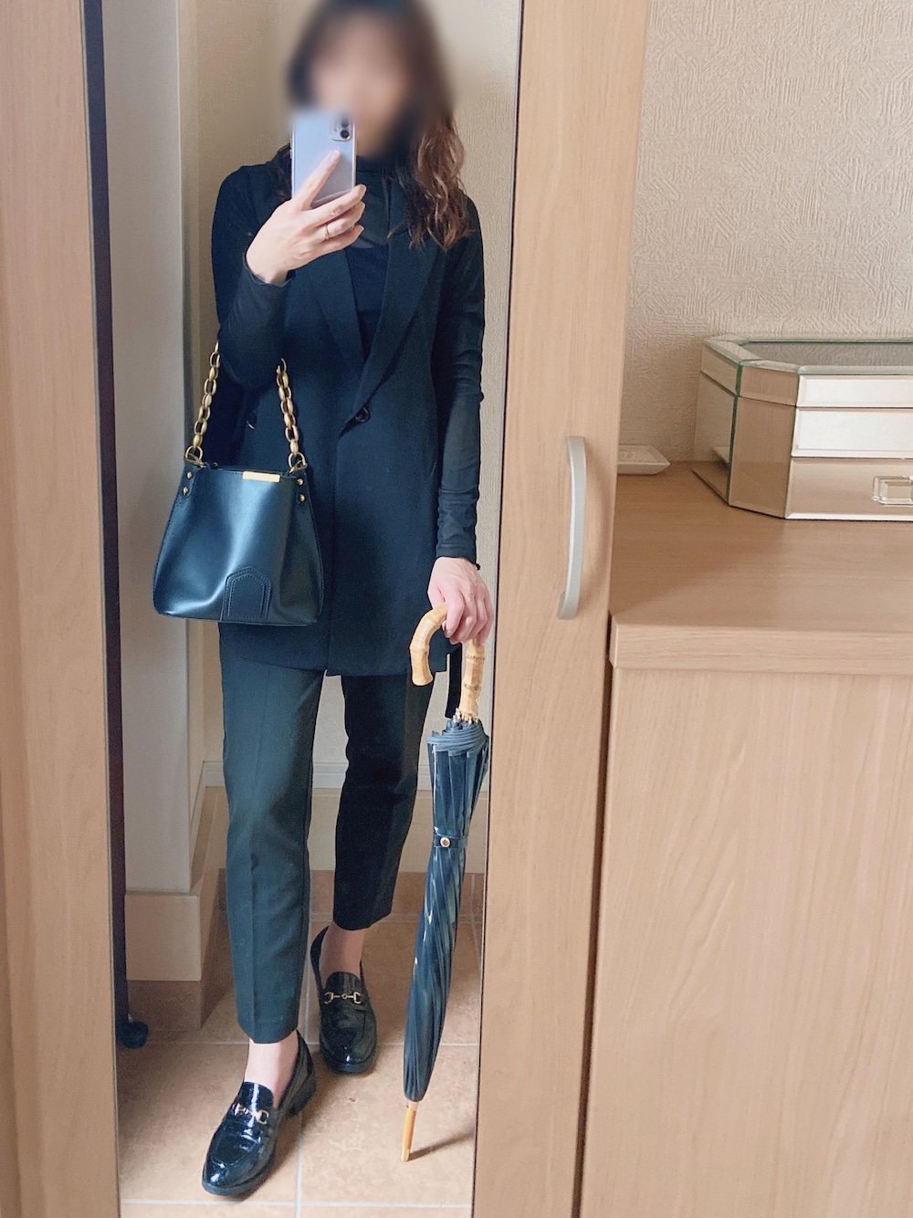 ブラック系のショルダーバッグ、ブラック系のシャツ/ブラウス、ブラック系のベストを着用したレディースの春コーディネートの1枚目の写真