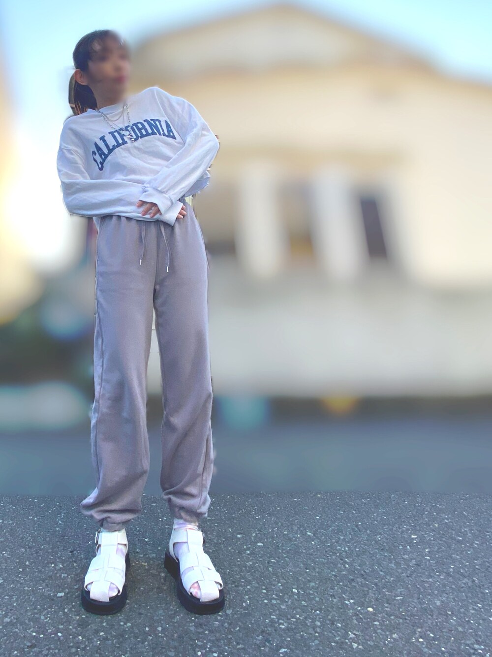 ホワイト系のスウェット、グレー系のスウェットパンツ、ホワイト系のサンダルを着用したレディースの春コーディネートの1枚目の写真