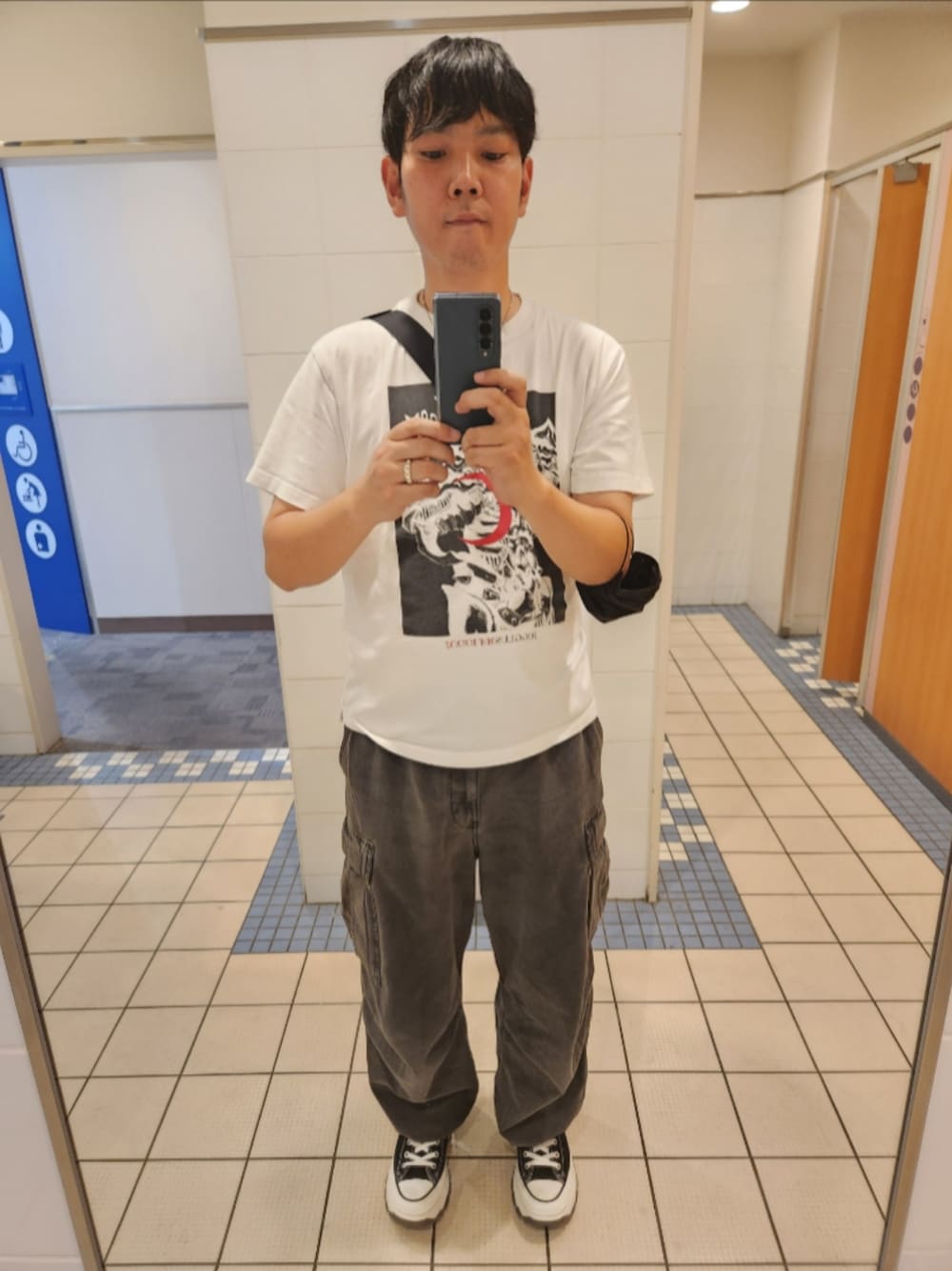 ホワイト系のTシャツ/カットソー、グレー系のカーゴパンツ、ブラック系のスニーカーを着用したメンズの秋コーディネートの1枚目の写真