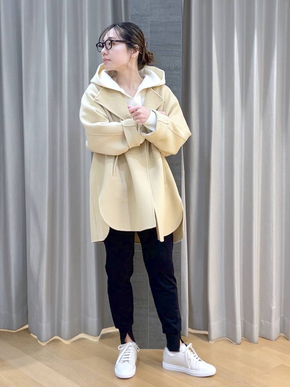 ベージュ系のノーカラージャケット、ブラック系のその他パンツ、ホワイト系のスニーカーを着用したレディースの冬コーディネートの1枚目の写真