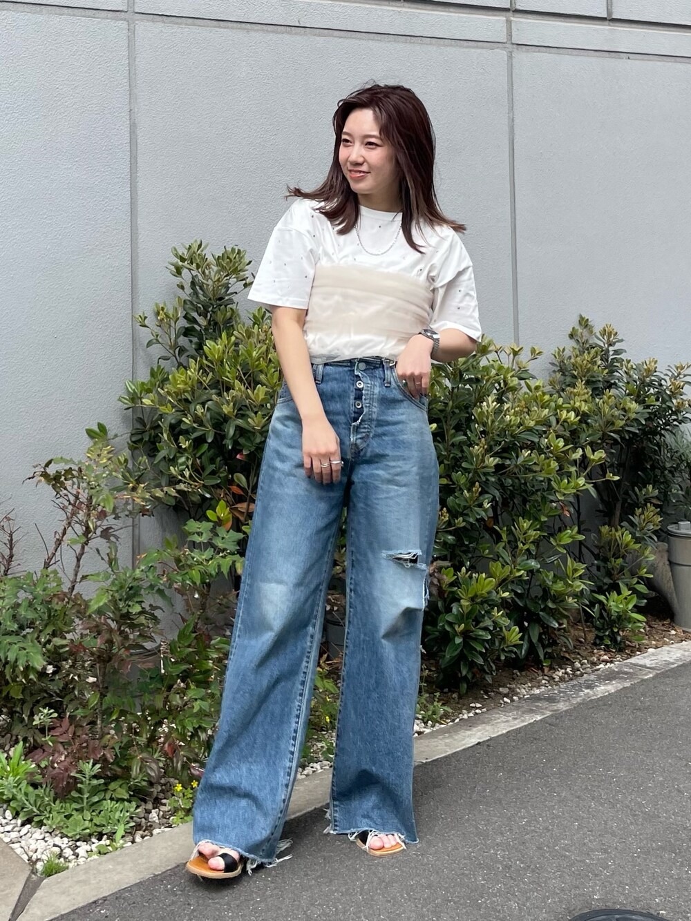 ホワイト系のTシャツ/カットソー、ベージュ系のキャミソール、ブルー系のデニムパンツを着用したレディースの春コーディネートの1枚目の写真