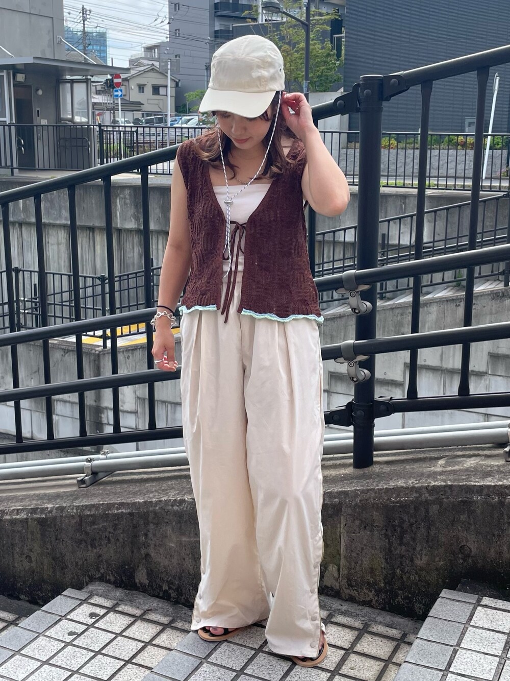 ブラウン系のニット/セーター、ホワイト系のその他パンツ、ブラック系のサンダルを着用したレディースの春コーディネートの1枚目の写真