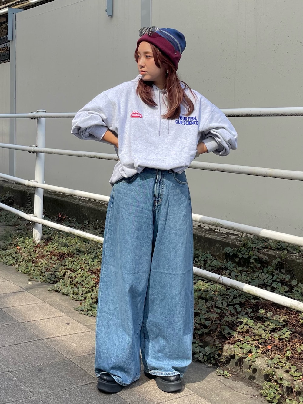 ホワイト系のパーカー、ブルー系のデニムパンツ、レッド系のニットキャップ/ビーニーを着用したレディースの秋コーディネートの1枚目の写真