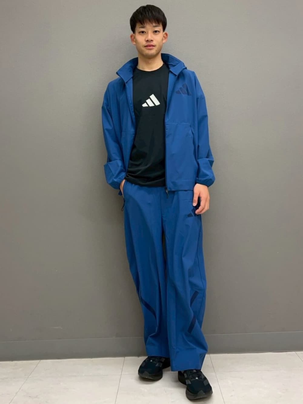 ブルー系のジャージ、ブルー系のその他パンツ、ブラック系のTシャツ/カットソーを着用したメンズの春コーディネートの1枚目の写真