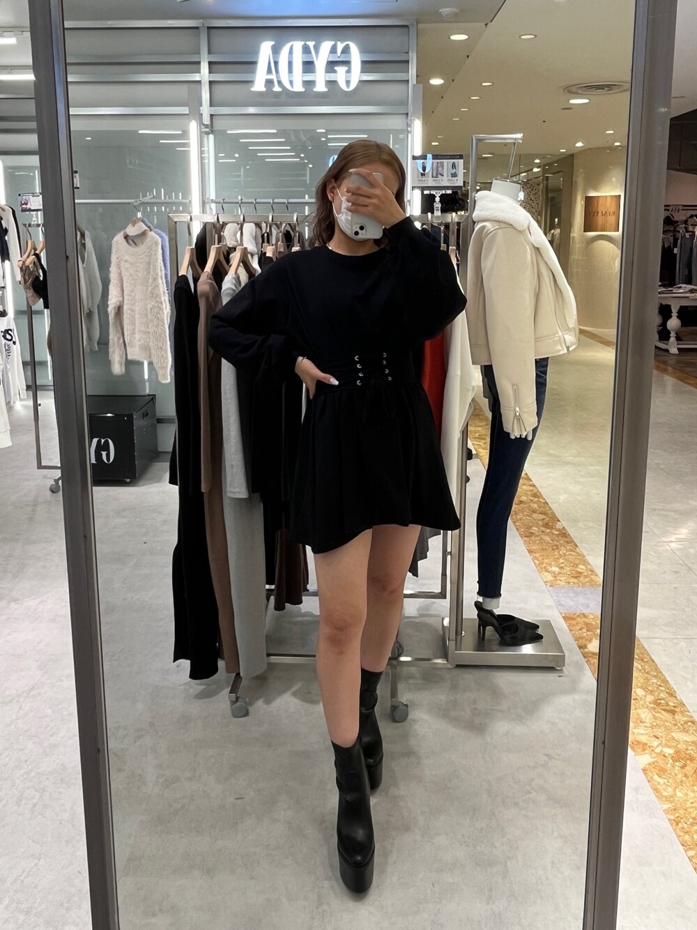 ブラック系のワンピース、ブラック系のブーツを着用したレディースの秋コーディネートの1枚目の写真