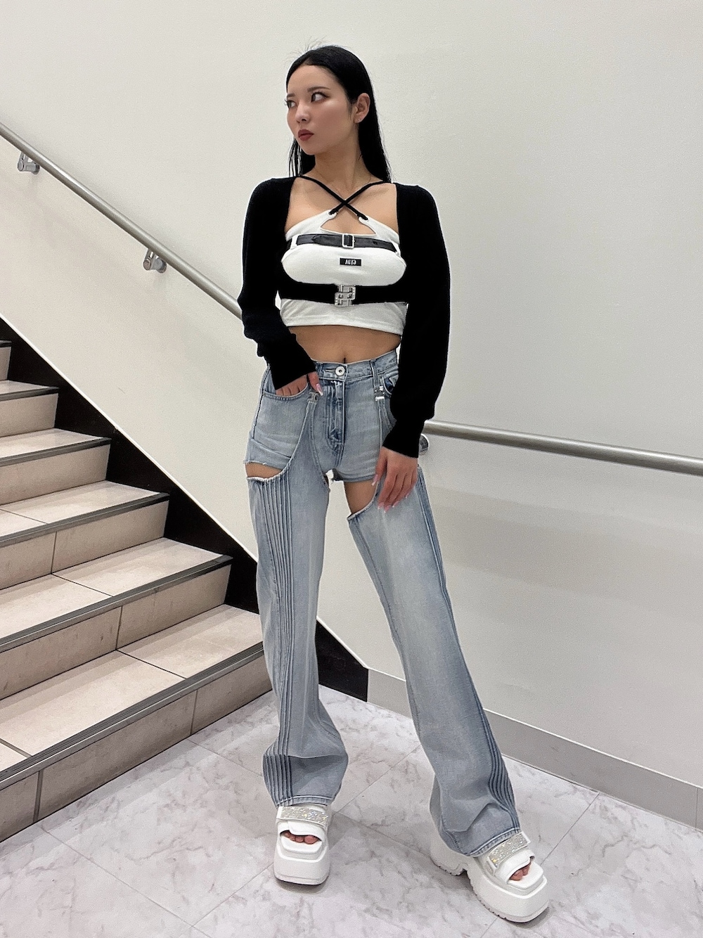 ホワイト系のキャミソール、ブラック系のカーディガン/ボレロ、ブルー系のデニムパンツを着用したレディースの春コーディネートの1枚目の写真