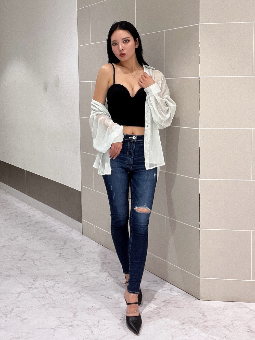 ブラック系のキャミソール、ブルー系のデニムパンツ、ブラック系のパンプスを着用したレディースの春コーディネートの1枚目の写真