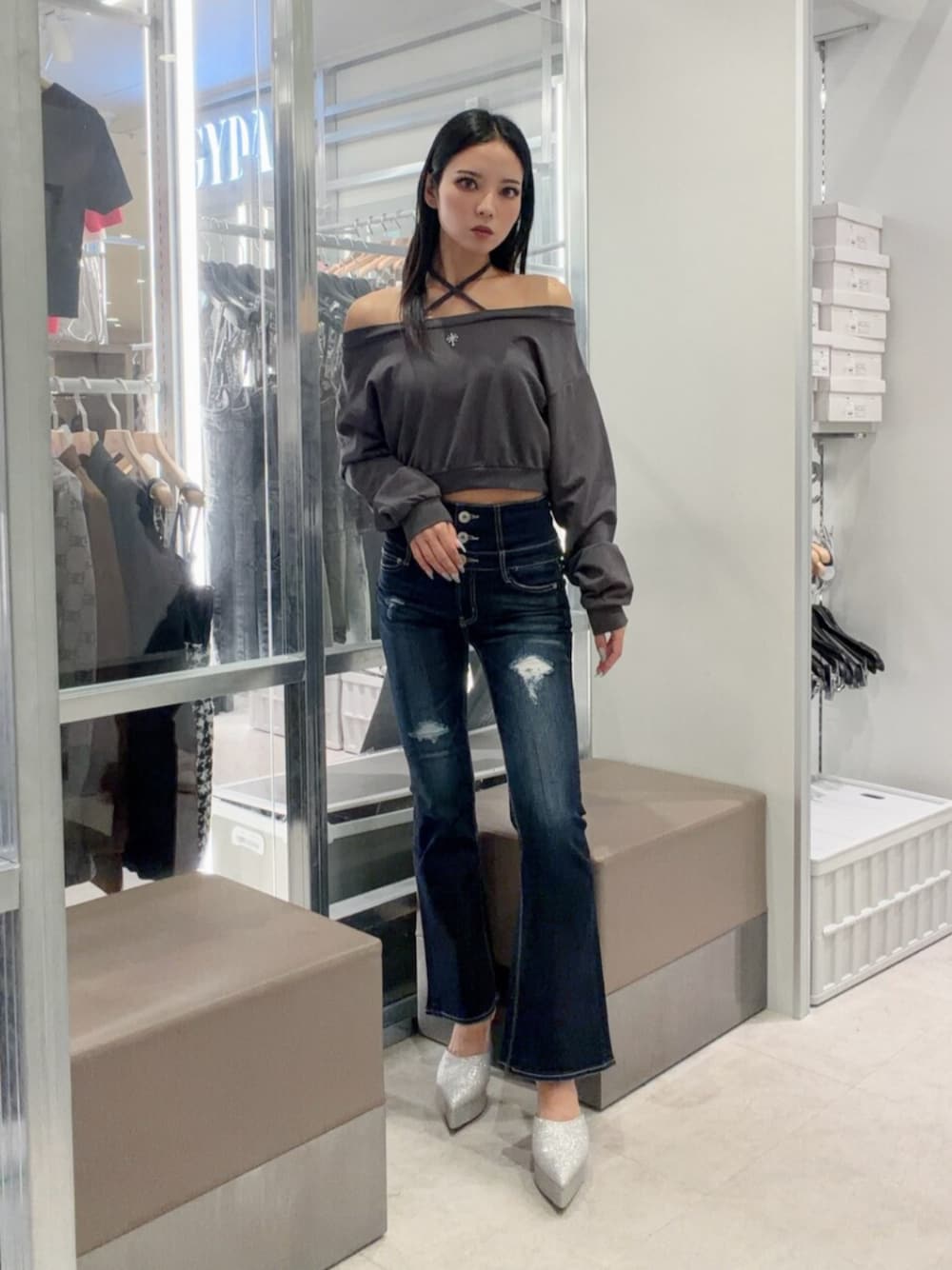 シルバー系のパンプス、ブルー系のデニムパンツ、グレー系のスウェットを着用したレディースの秋コーディネートの1枚目の写真