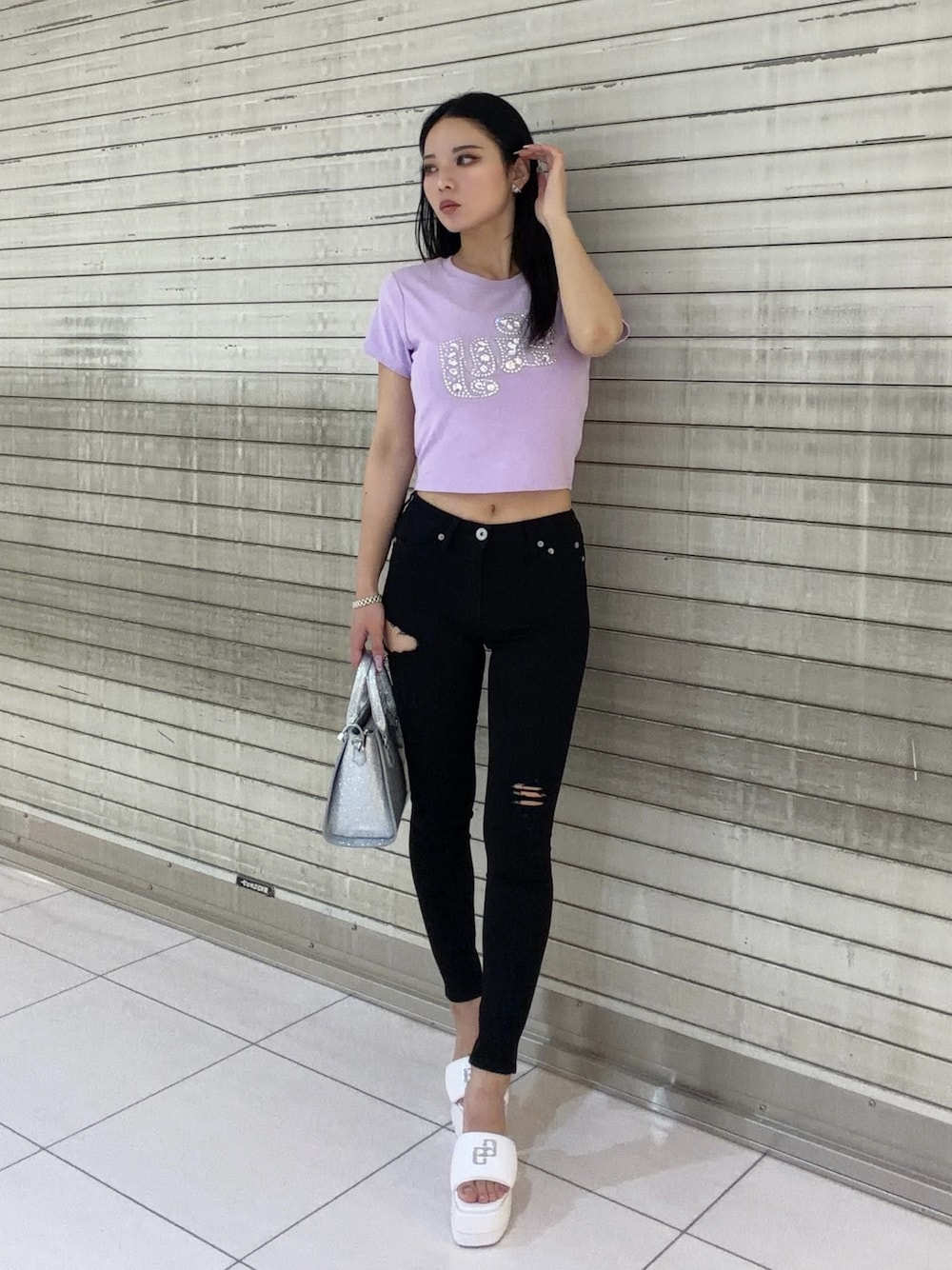 パープル系のTシャツ/カットソー、ブラック系のデニムパンツ、シルバー系のハンドバッグを着用したレディースの春コーディネートの1枚目の写真