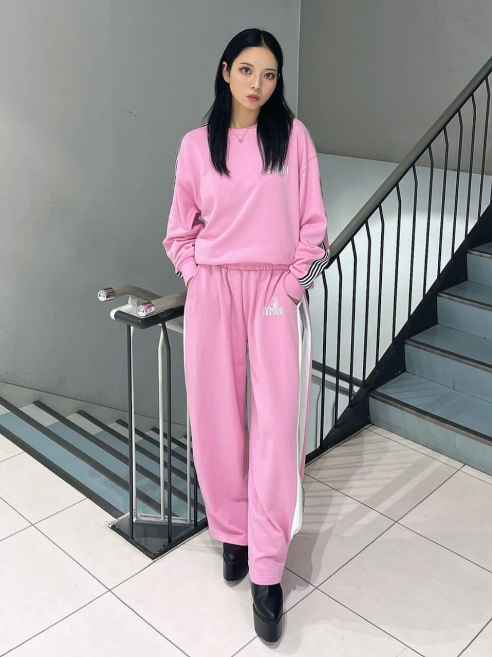 ブラック系のブーツ、ピンク系のスウェット、ピンク系のスウェットパンツを着用したレディースの冬コーディネートの1枚目の写真