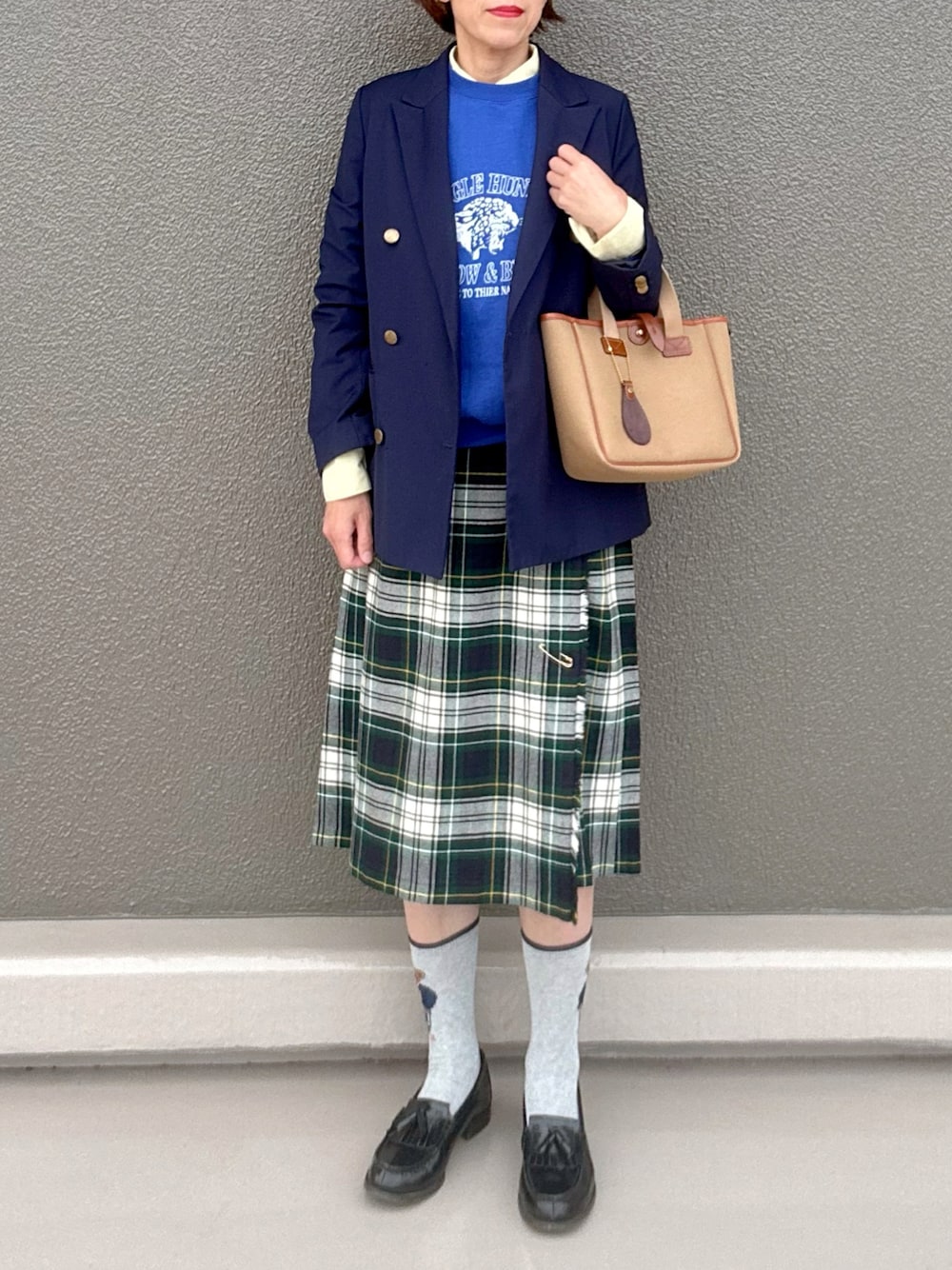 ホワイト系のスカート、ブルー系のテーラードジャケット、グリーン系のトートバッグを着用したレディースの秋コーディネートの1枚目の写真