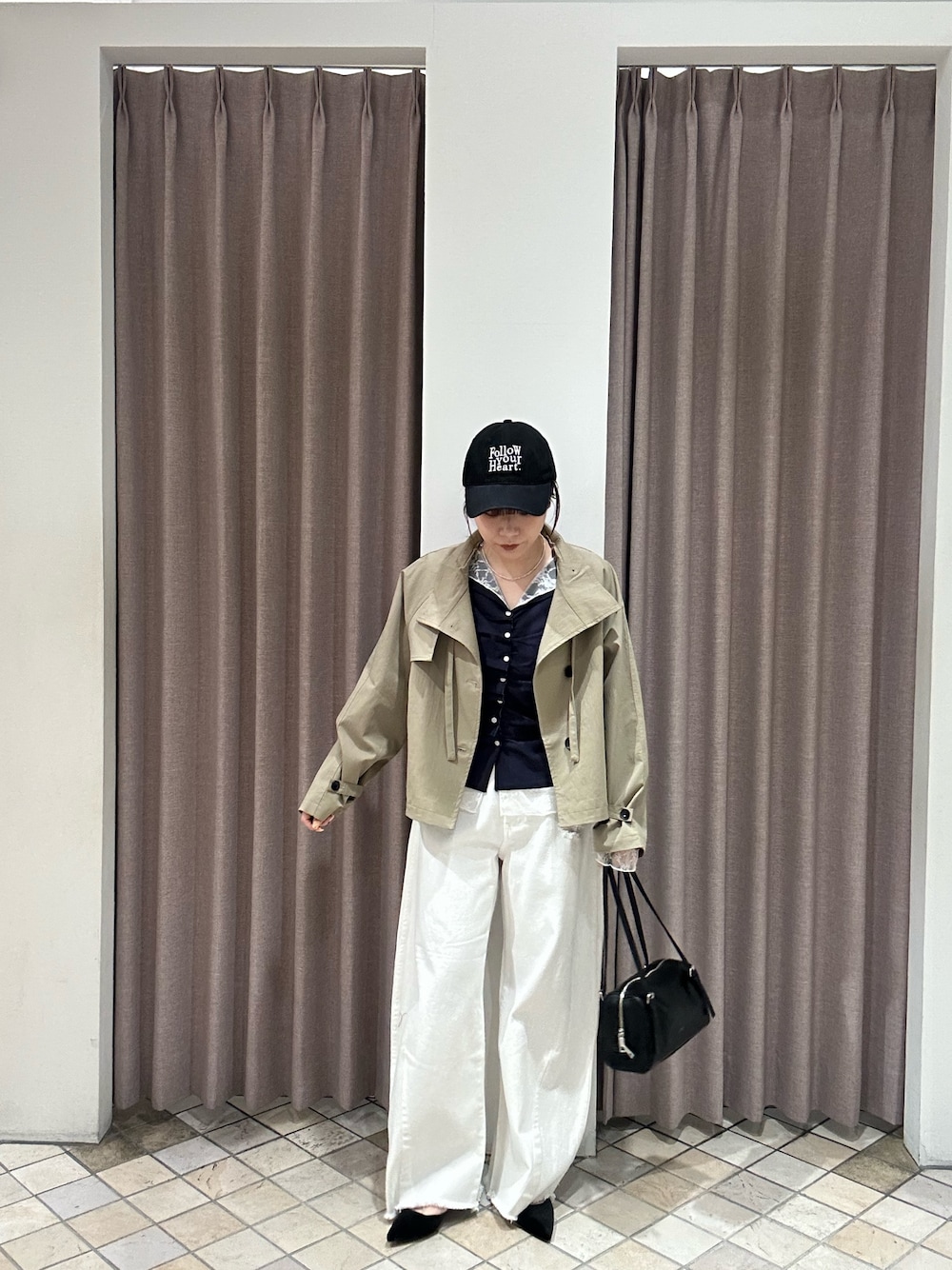 ホワイト系のデニムパンツ、ベージュ系のトレンチコート、ブルー系のTシャツ/カットソーを着用したレディースの冬コーディネートの1枚目の写真