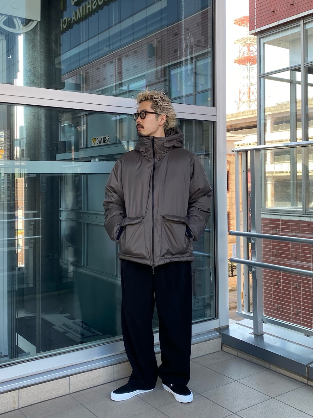 グレー系のダウンジャケット/コート、ブラック系のスリッポン、ブルー系のその他パンツを着用したメンズの秋コーディネートの1枚目の写真