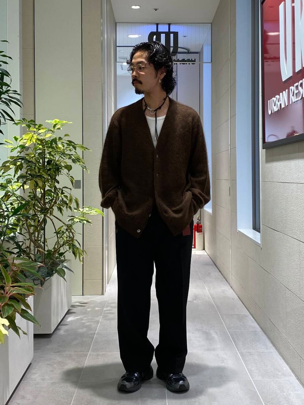 ブラック系のスラックス、ブラック系のスニーカー、ブラウン系のカーディガン/ボレロを着用したメンズの秋コーディネートの1枚目の写真