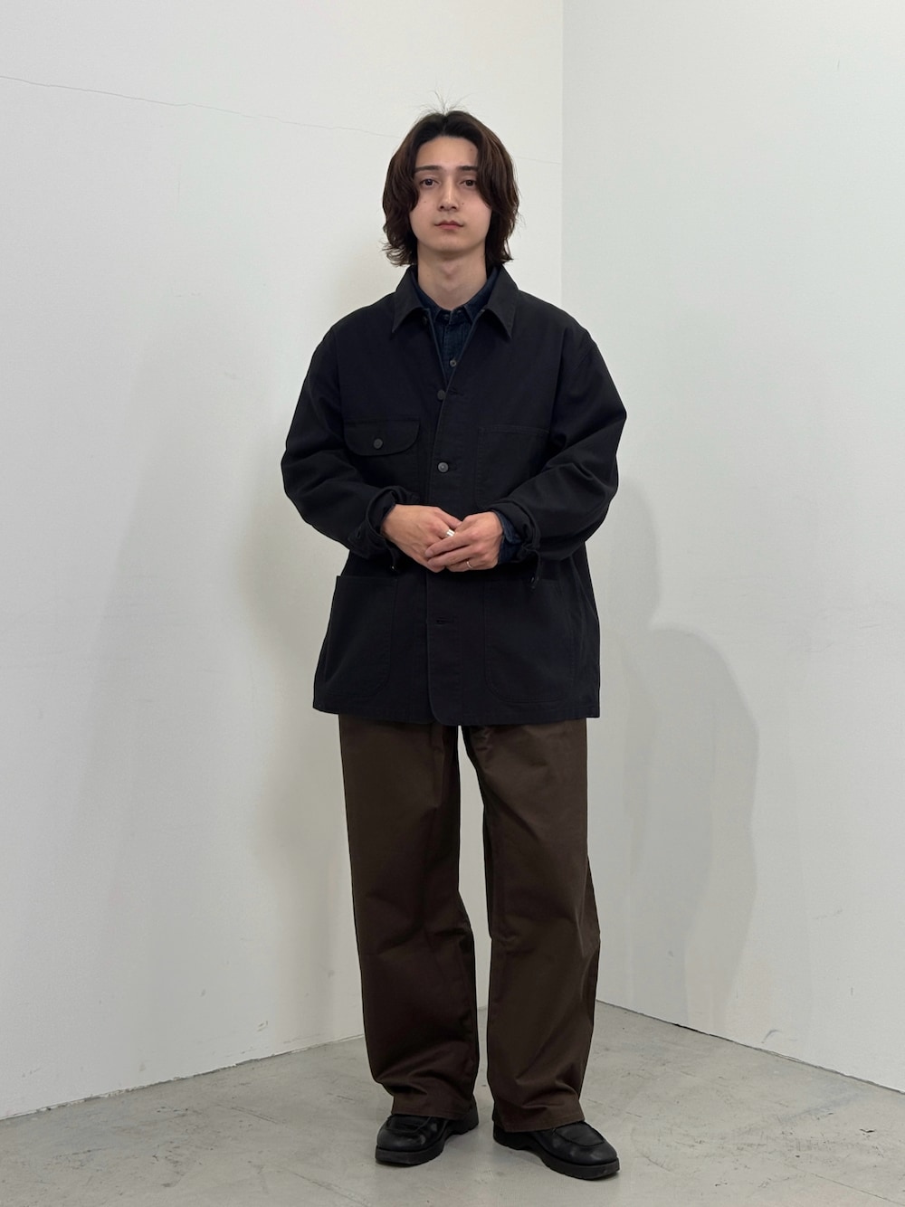 ブルー系のシャツ/ブラウス、ブラック系のジャケット/アウター、ブラウン系のパンツを着用したメンズの秋コーディネートの1枚目の写真