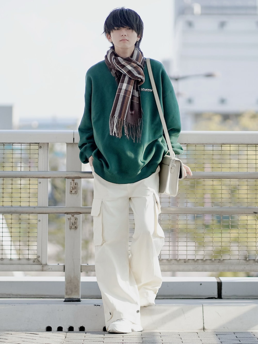 グリーン系のスウェット、ホワイト系のショルダーバッグ、ホワイト系のカーゴパンツを着用したメンズの冬コーディネートの1枚目の写真