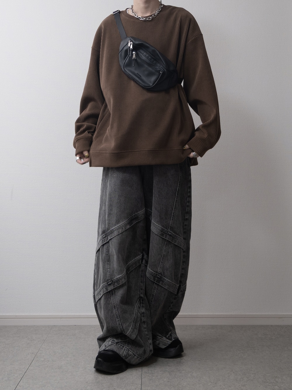 ブラウン系のスウェット、ブラック系のボディバッグ/ウエストポーチ、ブラック系のデニムパンツを着用したメンズの秋コーディネートの1枚目の写真