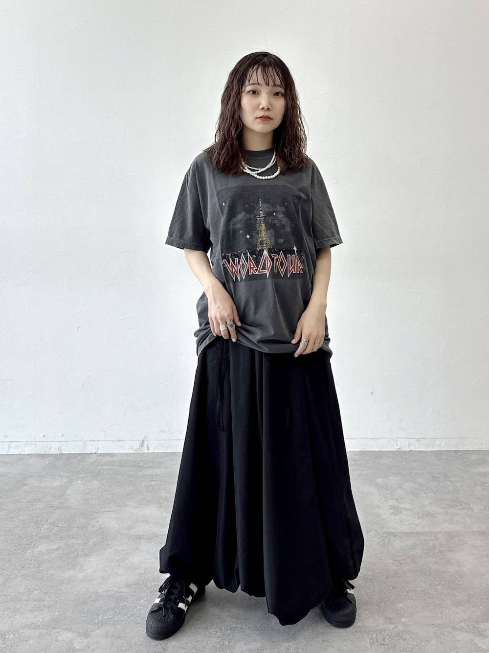 ブラック系のスカートを着用したレディースの夏コーディネートの1枚目の写真