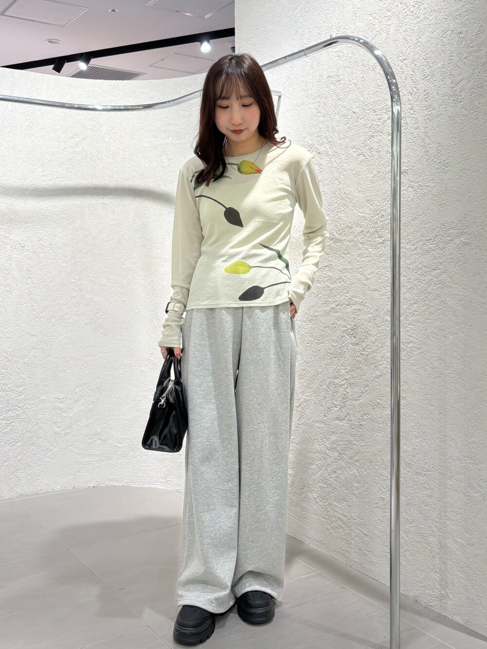 グリーン系のTシャツ/カットソー、ブラック系のボストンバッグ、ブラック系のスニーカーを着用したレディースの冬コーディネートの1枚目の写真