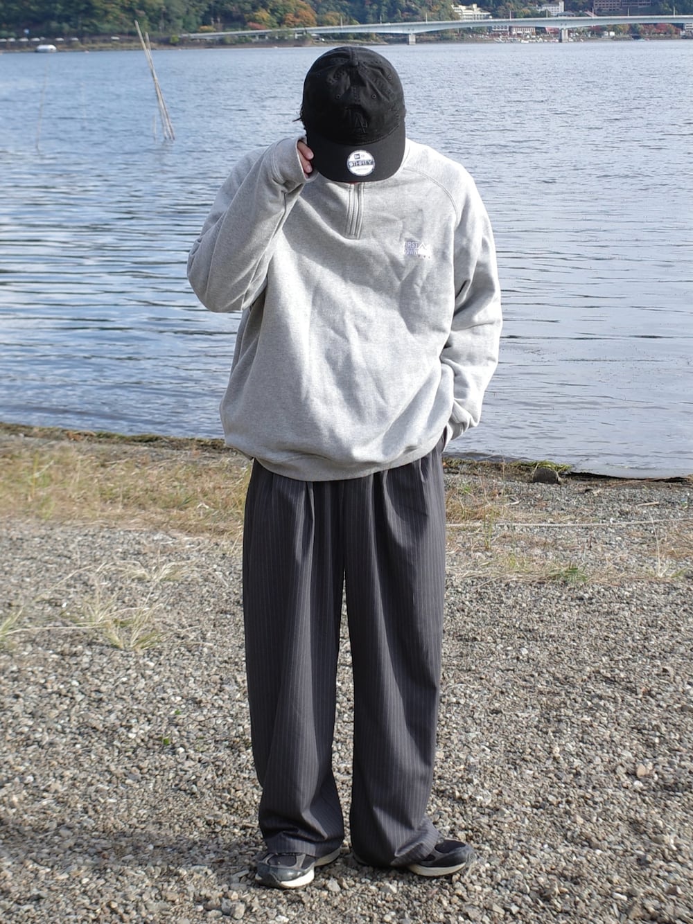 グレー系のスウェット、グレー系のスラックスを着用したメンズの秋コーディネートの1枚目の写真