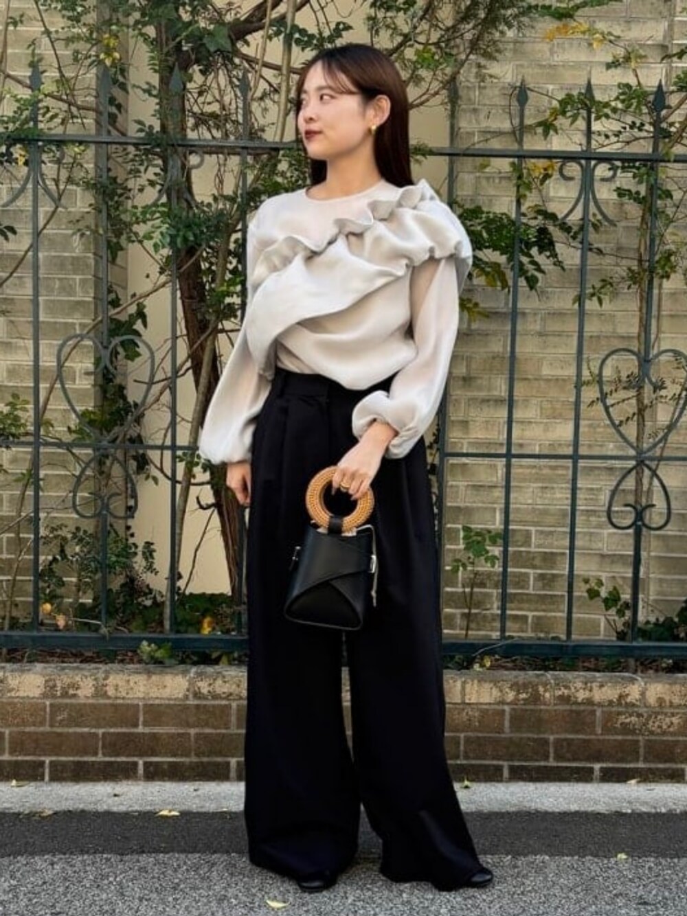 シルバー系のシャツ/ブラウス、ブラック系のスラックスを着用したレディースの春コーディネートの1枚目の写真