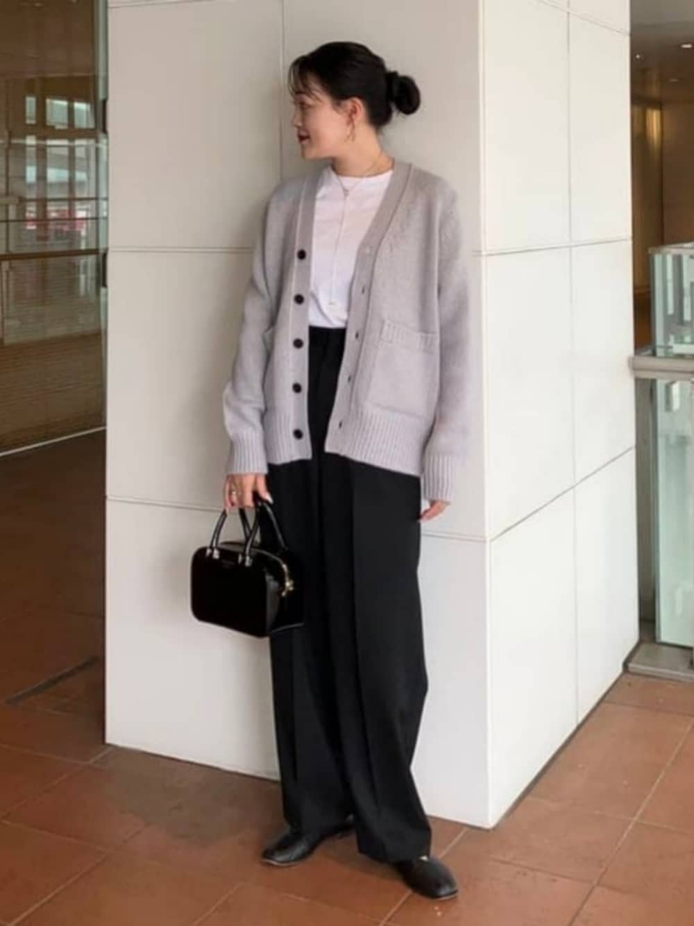 ブラック系のその他パンツ、ブラック系のトートバッグ、グレー系のカーディガン/ボレロを着用したレディースの秋コーディネートの1枚目の写真