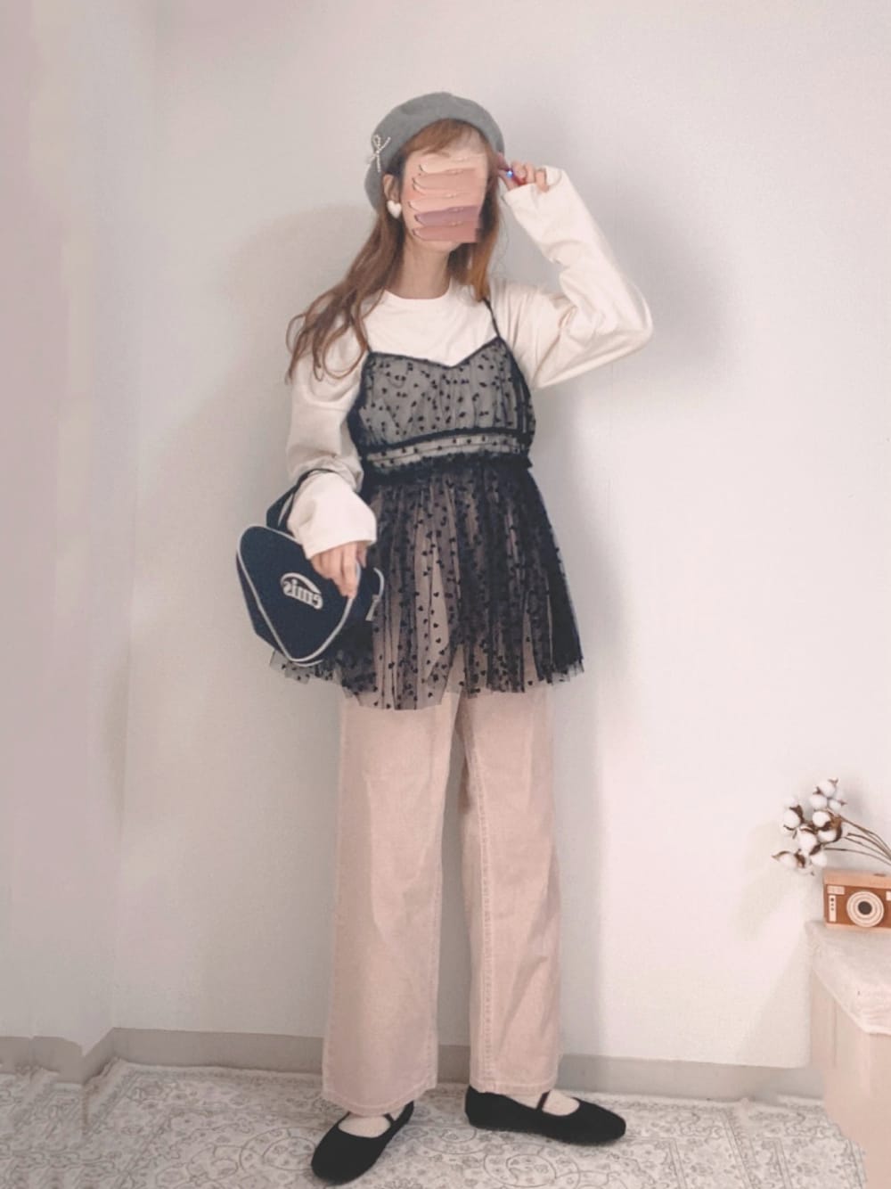 ピンク系のデニムパンツ、ブラック系のキャミソール、ブラック系のハンドバッグを着用したレディースの冬コーディネートの1枚目の写真