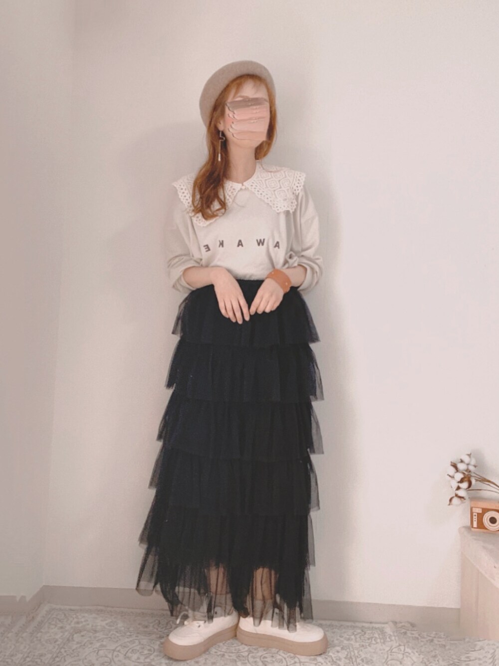 ブラック系のスカート、ホワイト系のTシャツ/カットソー、ベージュ系のスニーカーを着用したレディースの春コーディネートの1枚目の写真