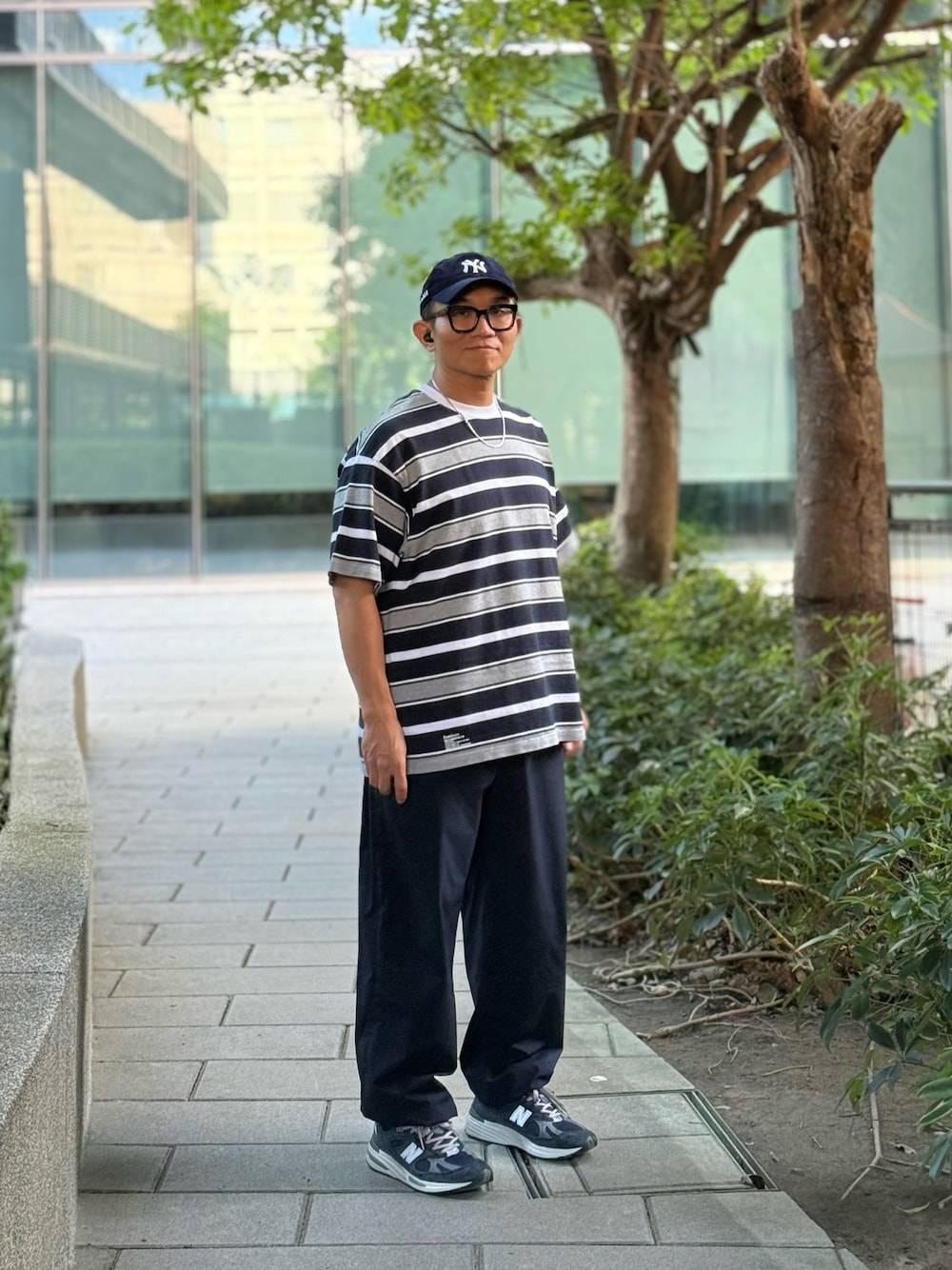 グレー系のTシャツ/カットソー、ブルー系のチノパンツ、ブルー系のスニーカーを着用したメンズの秋コーディネートの1枚目の写真