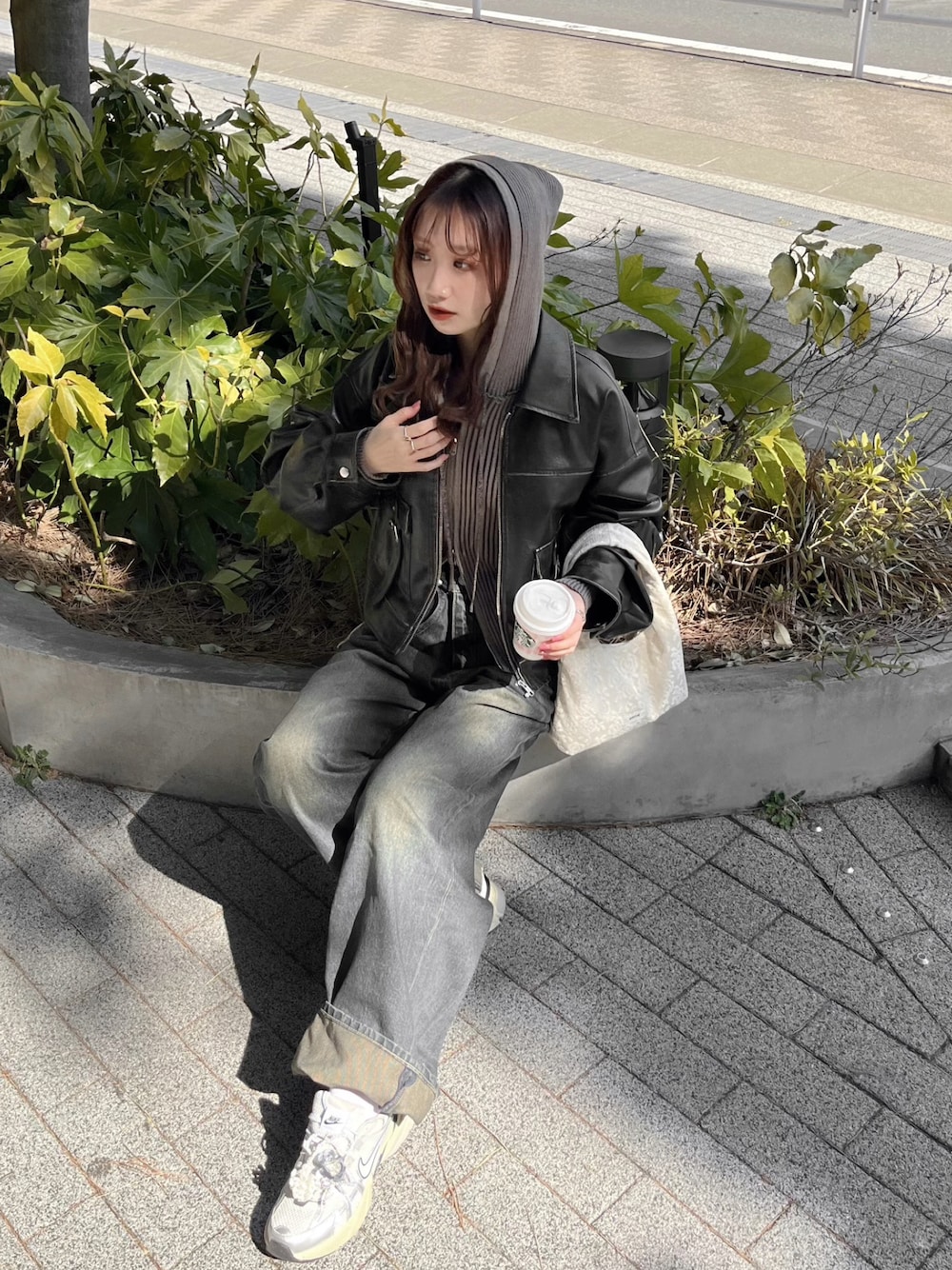 ブラック系のブルゾン、ブルー系のデニムパンツ、ホワイト系のスニーカーを着用したレディースの秋コーディネートの1枚目の写真