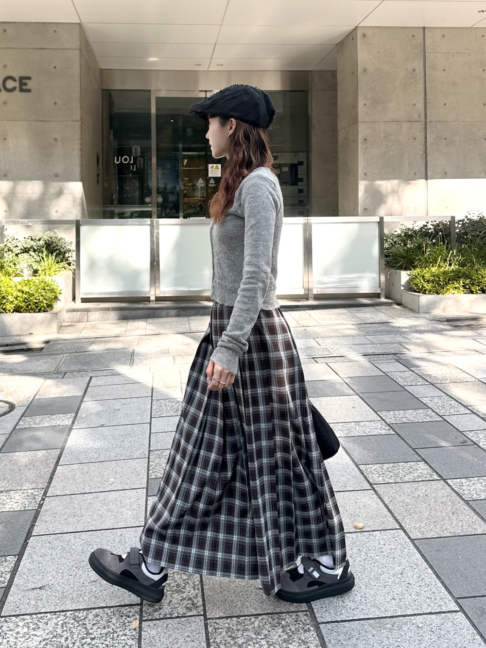 ブラウン系のスカートを着用したレディースの秋コーディネートの1枚目の写真