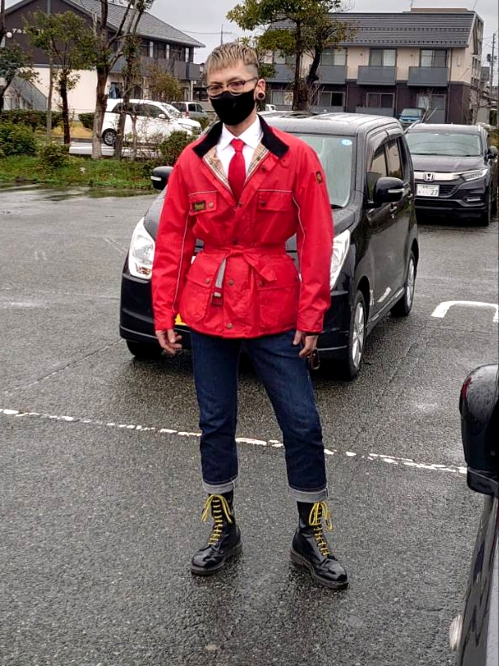 レッド系のライダースジャケット、ブルー系のデニムパンツ、ブラック系のブーツを着用したメンズの春コーディネートの2枚目の写真