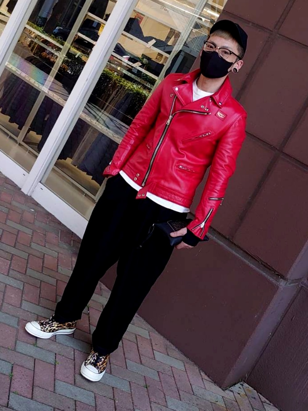 レッド系のライダースジャケット、ブラック系のスラックス、その他のスニーカーを着用したメンズの春コーディネートの2枚目の写真
