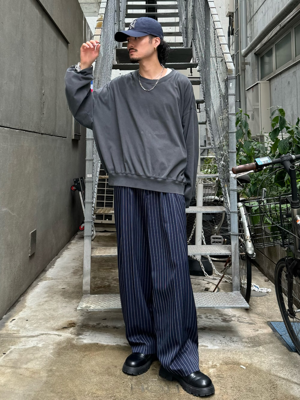 グレー系のTシャツ/カットソー、ブルー系のその他パンツ、ブラック系のブーツを着用したメンズの秋コーディネートの1枚目の写真