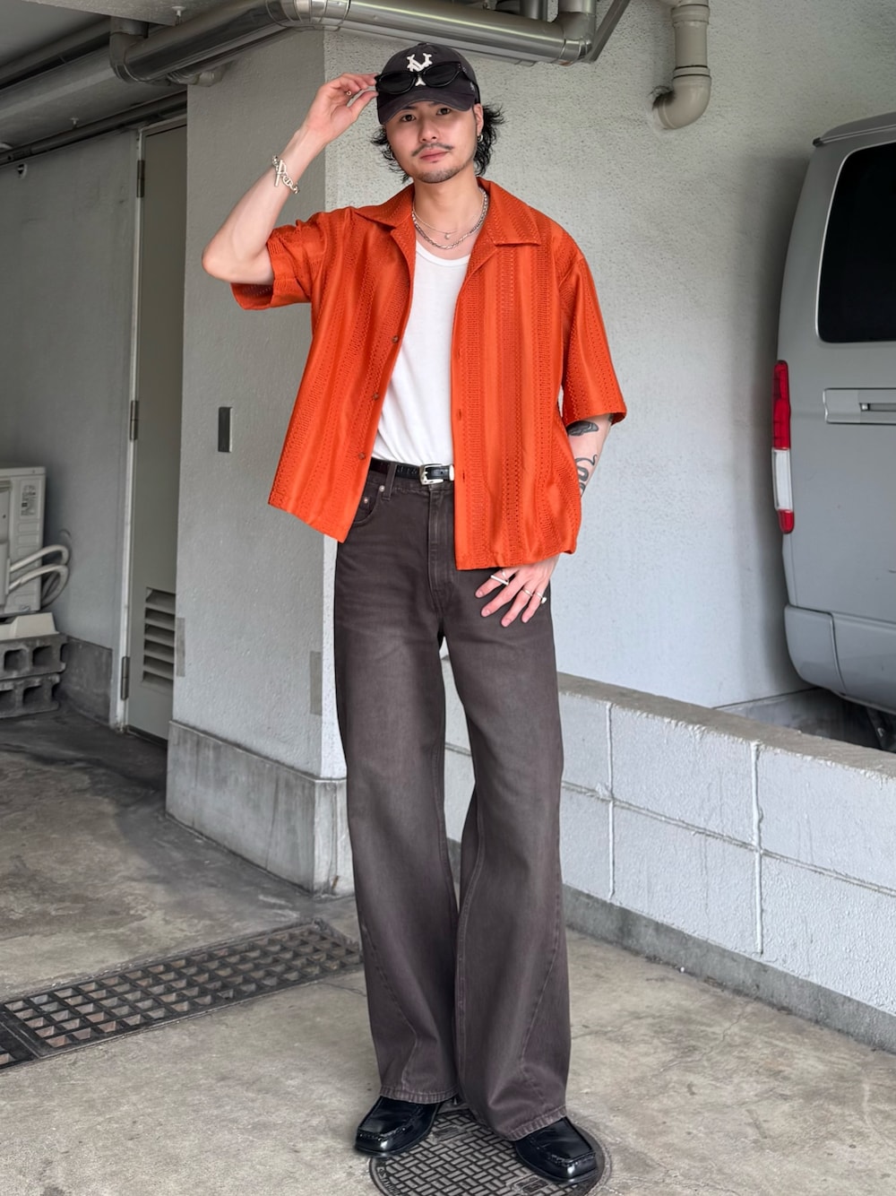 オレンジ系のシャツ/ブラウス、ブラウン系のデニムパンツを着用したメンズの夏コーディネートの1枚目の写真