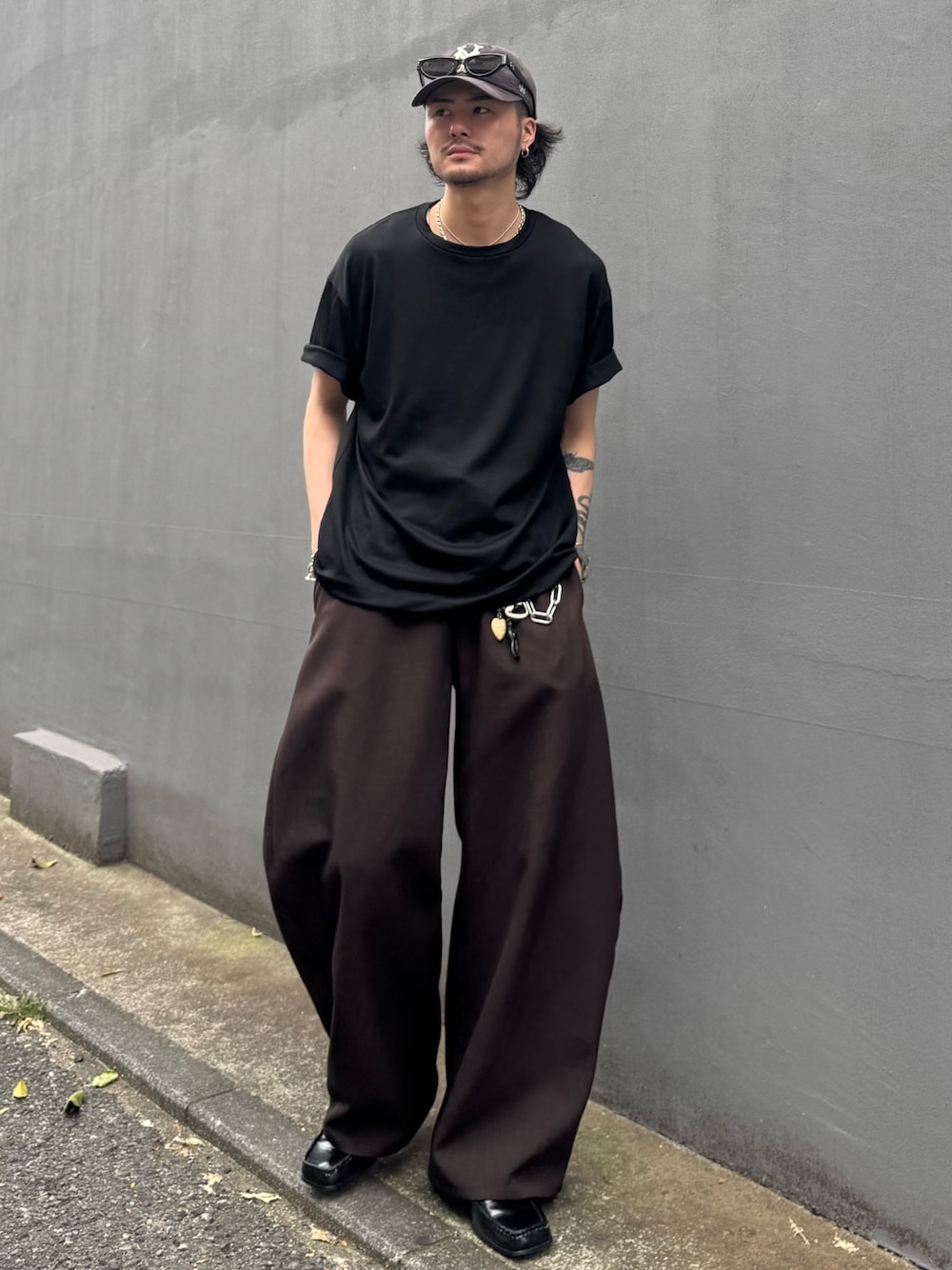 ブラック系のTシャツ/カットソー、グレー系のスラックスを着用したメンズの夏コーディネートの1枚目の写真
