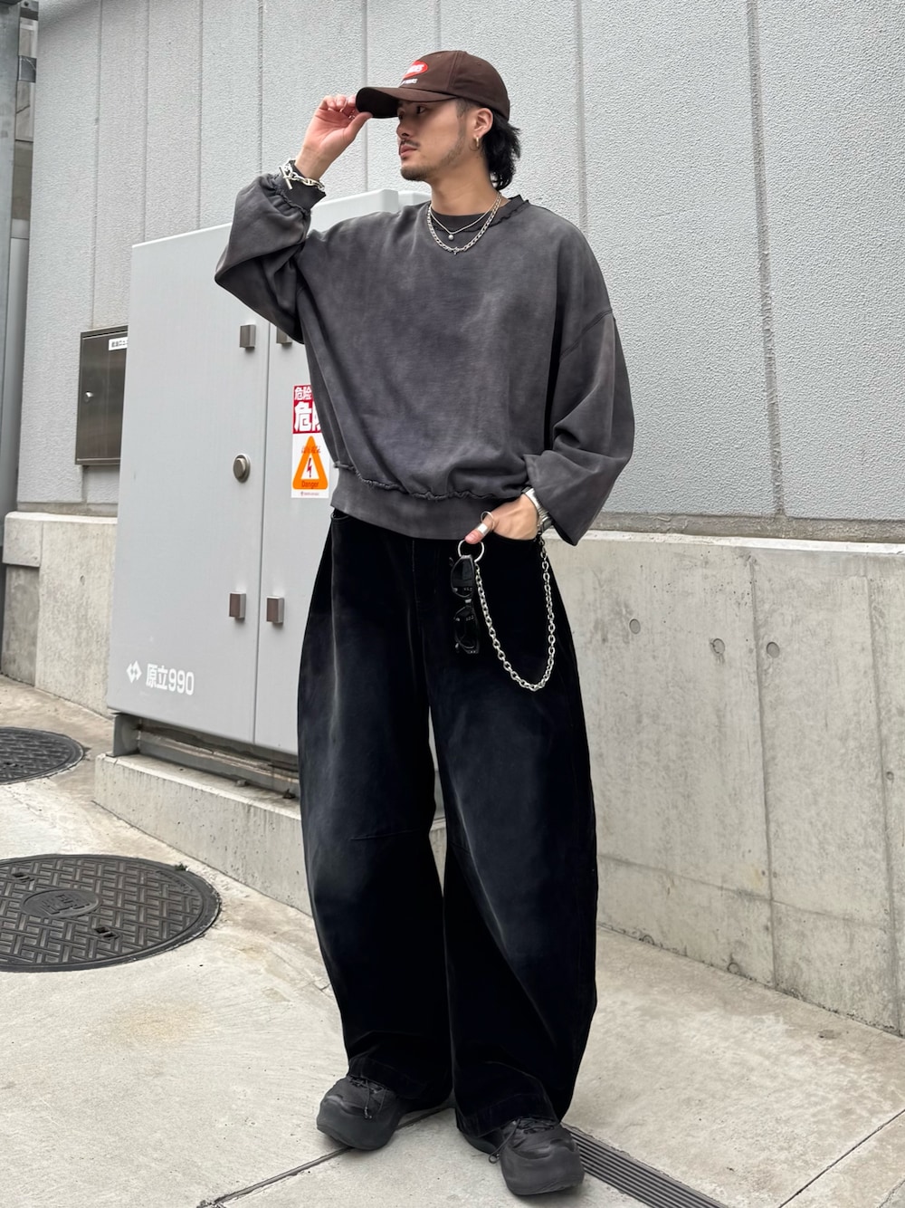 ブラック系のスウェット、ブラック系のデニムパンツ、シルバー系のウォレットチェーンを着用したメンズの春コーディネートの1枚目の写真