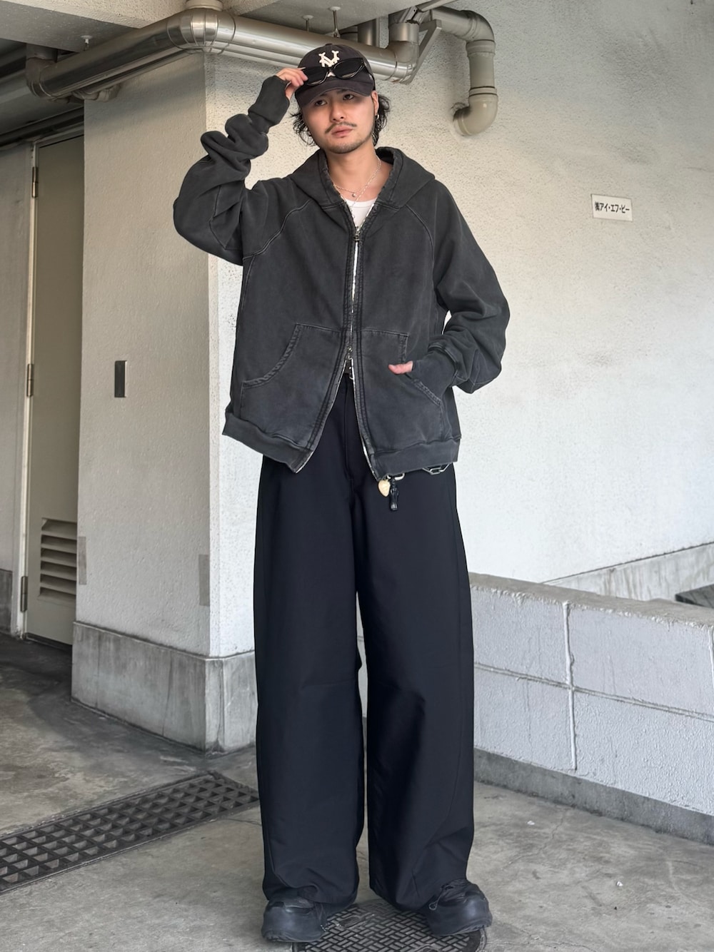 ブラック系のパーカー、ブラック系のスラックスを着用したメンズの春コーディネートの1枚目の写真