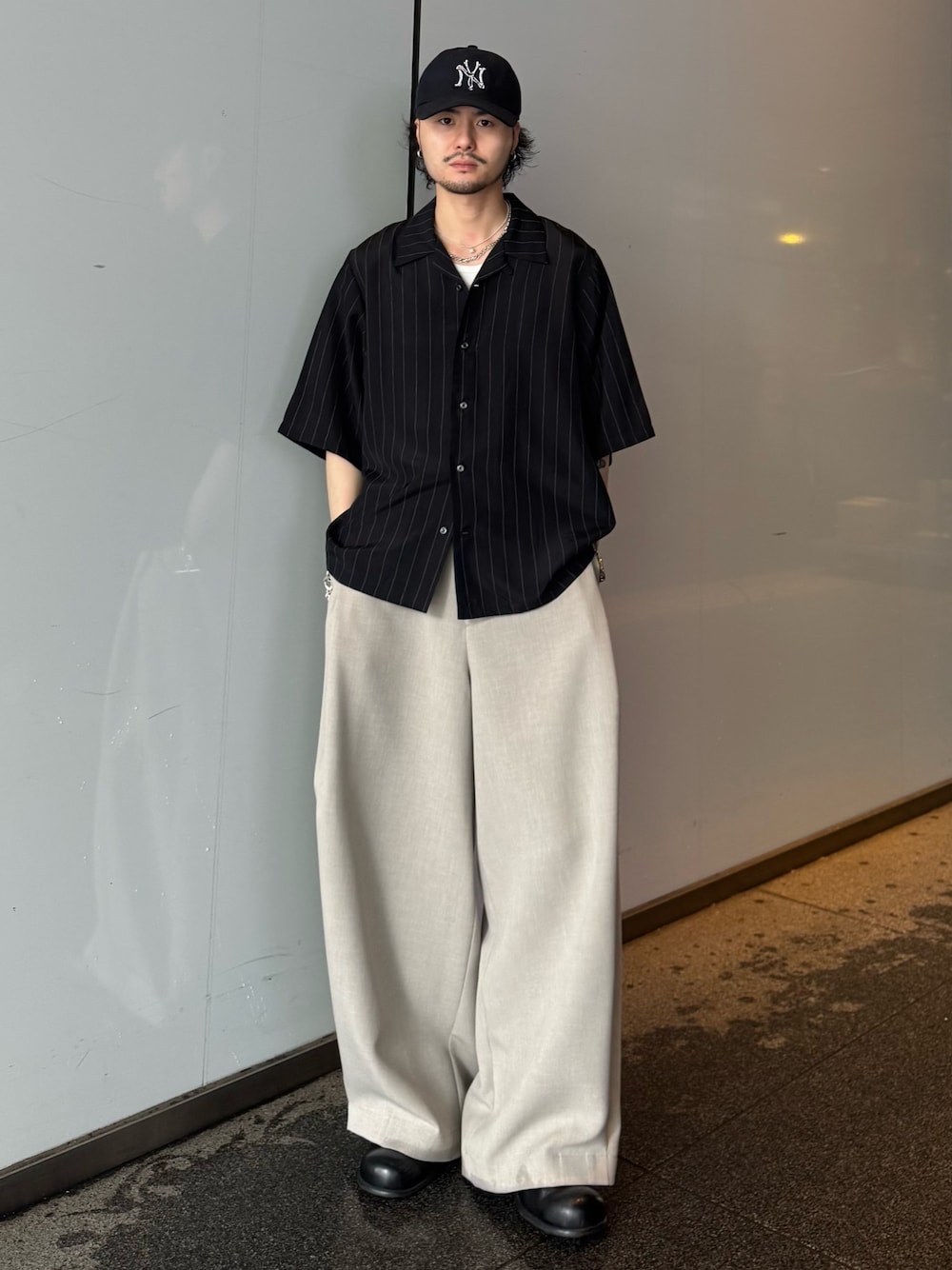 ブラック系のシャツ/ブラウス、ベージュ系のスラックスを着用したメンズの春コーディネートの1枚目の写真