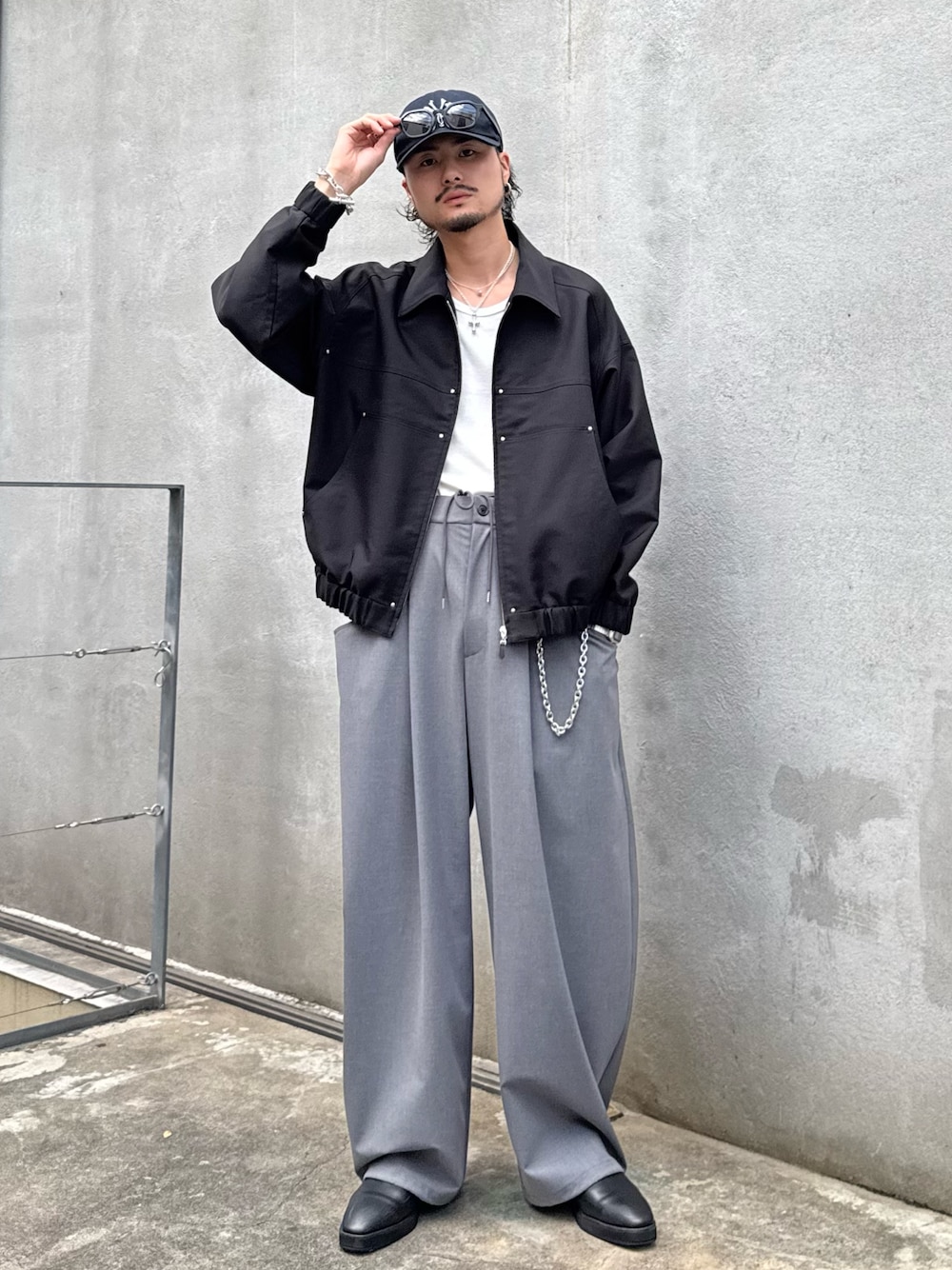 ブラック系のブルゾン、グレー系のスラックスを着用したメンズの秋コーディネートの1枚目の写真