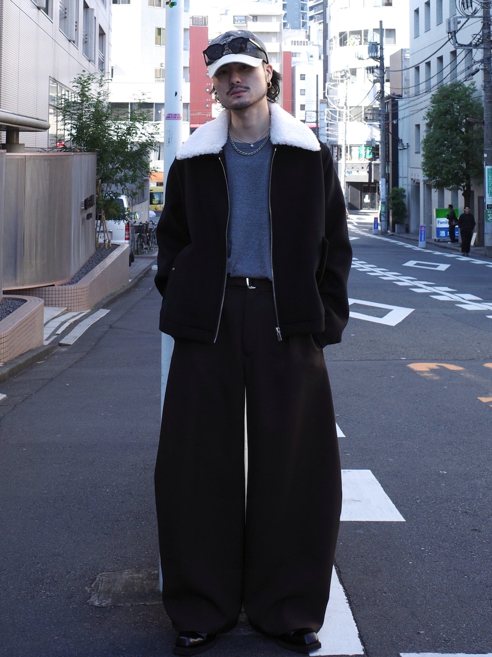 グレー系のニット/セーター、ブラック系のブルゾン、グレー系のスラックスを着用したメンズの秋コーディネートの1枚目の写真