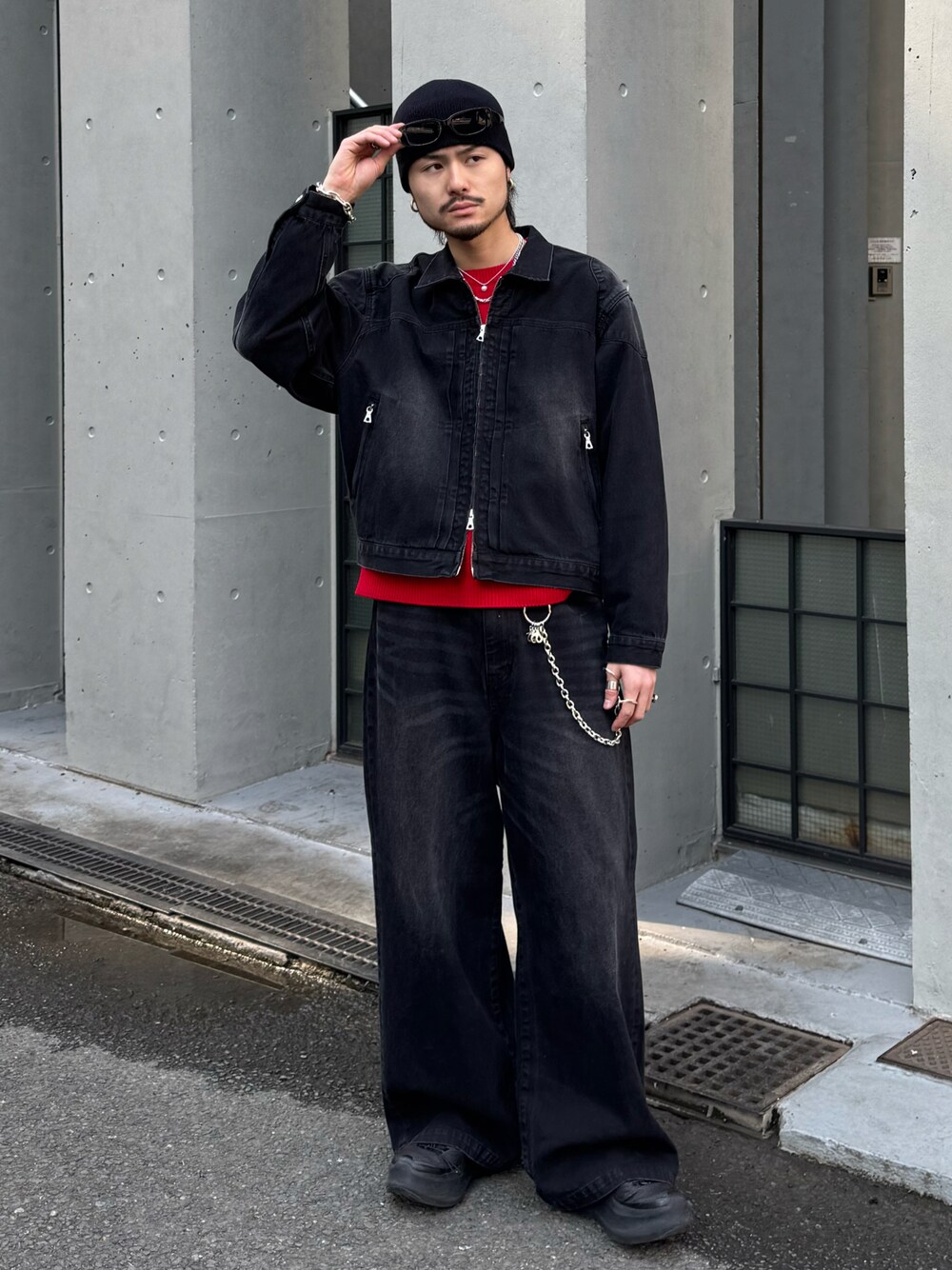ブラック系のブルゾン、ブラック系のデニムパンツ、レッド系のニット/セーターを着用したメンズの冬コーディネートの1枚目の写真