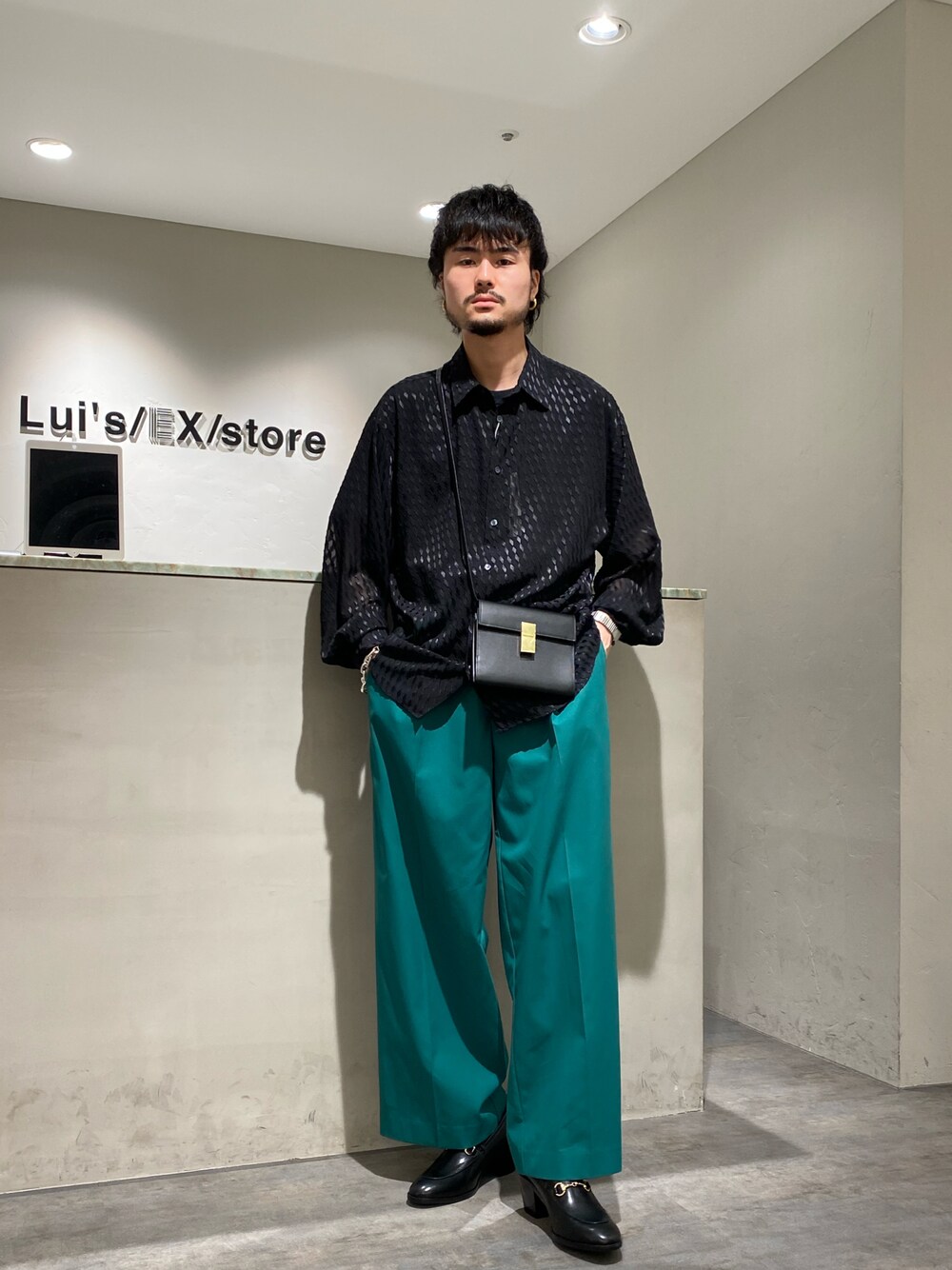 ブラック系のシャツ/ブラウス、ブラック系のショルダーバッグ、グリーン系のスラックスを着用したメンズの春コーディネートの1枚目の写真