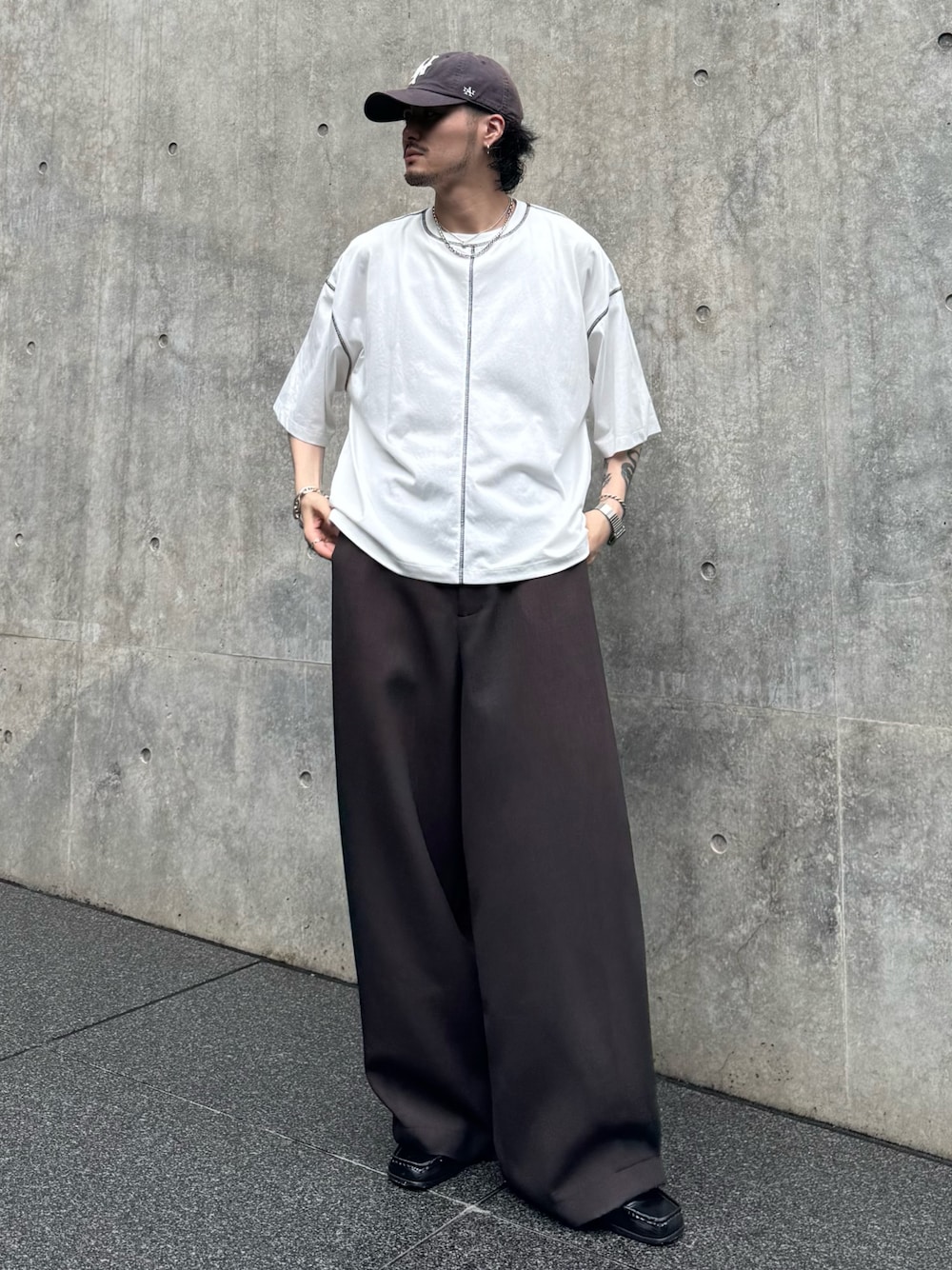 ホワイト系のTシャツ/カットソー、ブラウン系のスラックスを着用したメンズの夏コーディネートの1枚目の写真